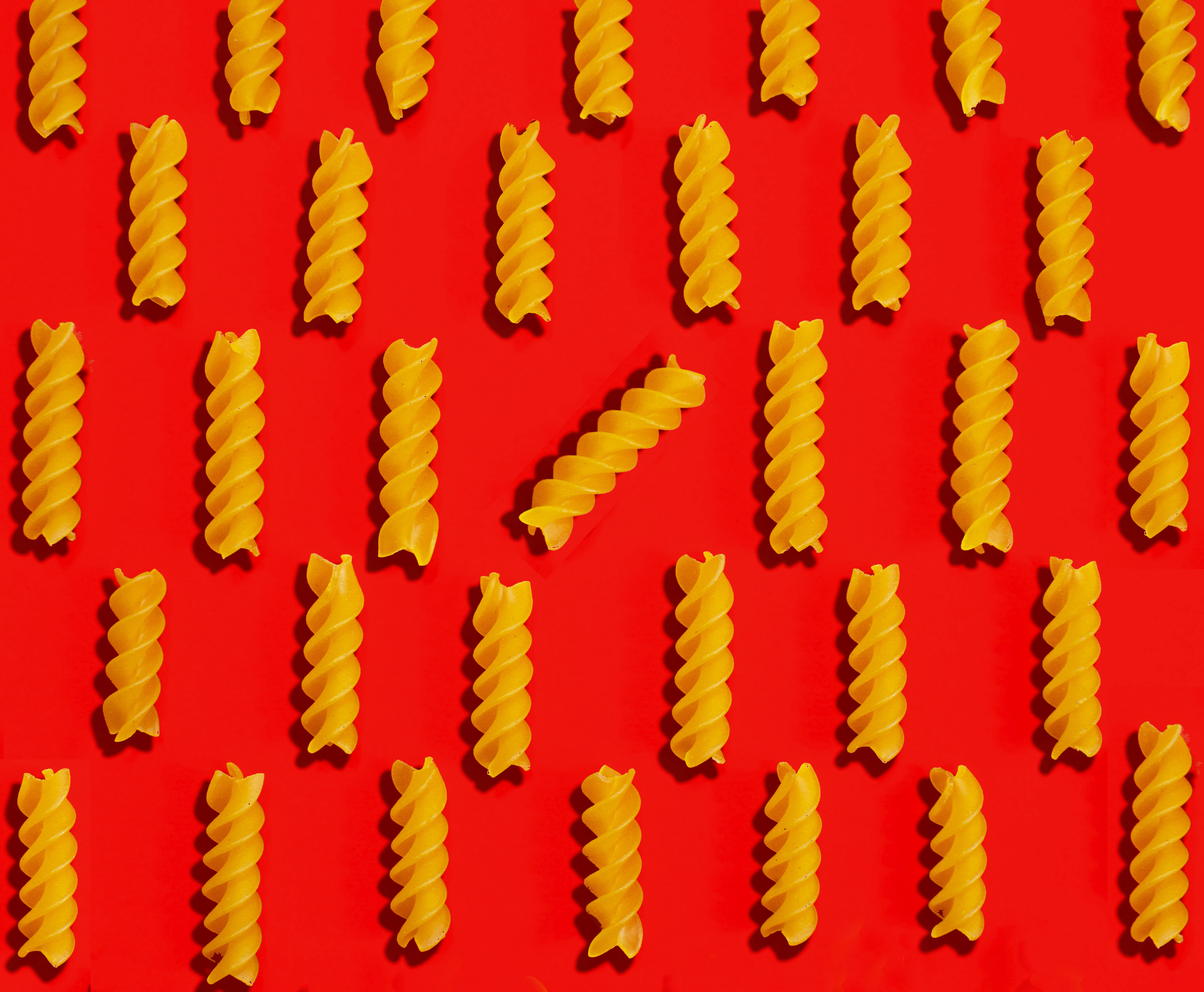 A close up of a bunch of pasta noodles on a red background