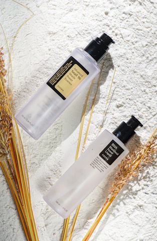 A couple of bottles of lotion sitting on top of a table