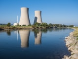 A body of water with two cooling towers in the background