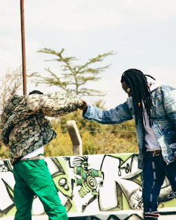A couple of men standing next to each other on a skateboard