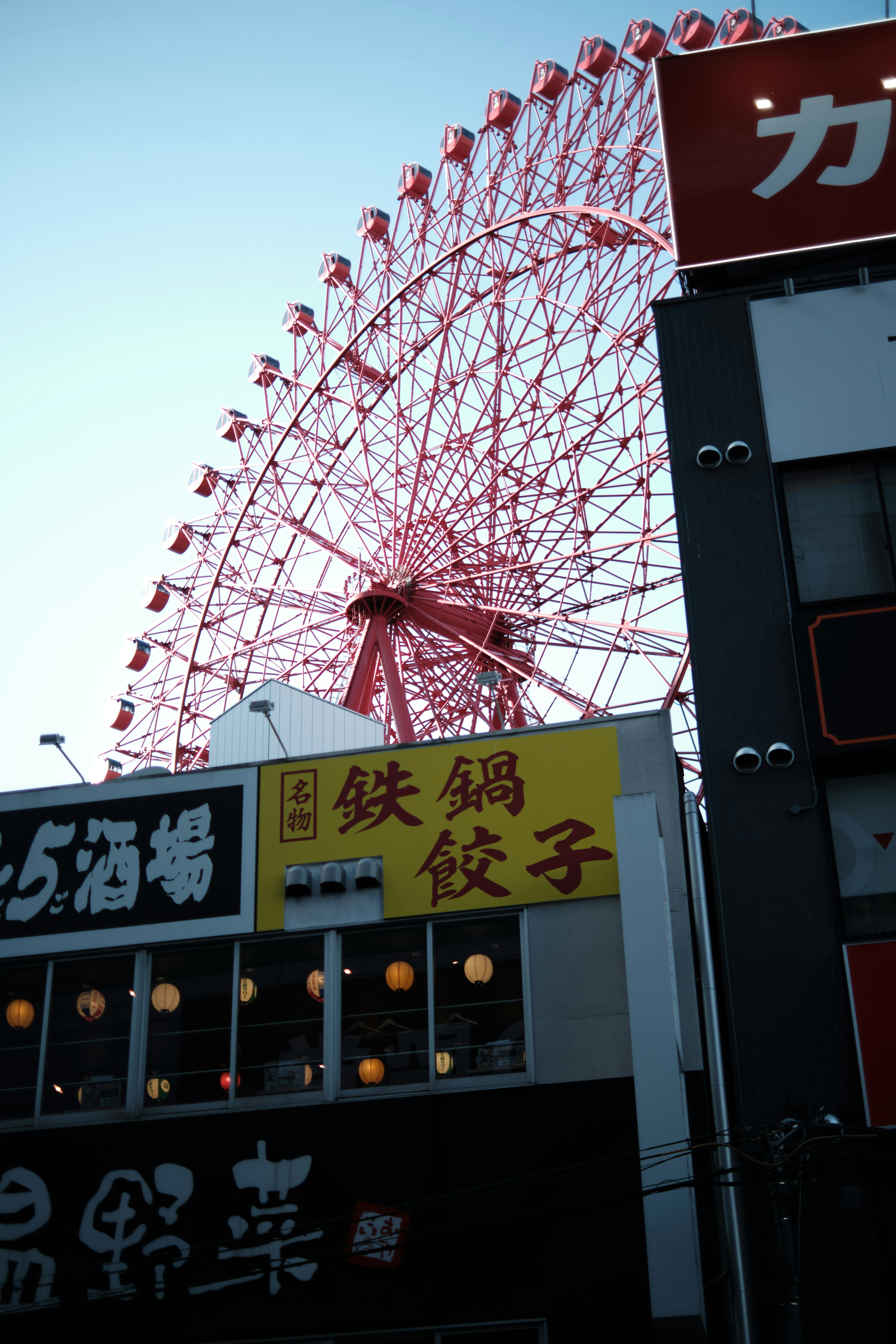 A large ferris wheel sitting next to a tall building
