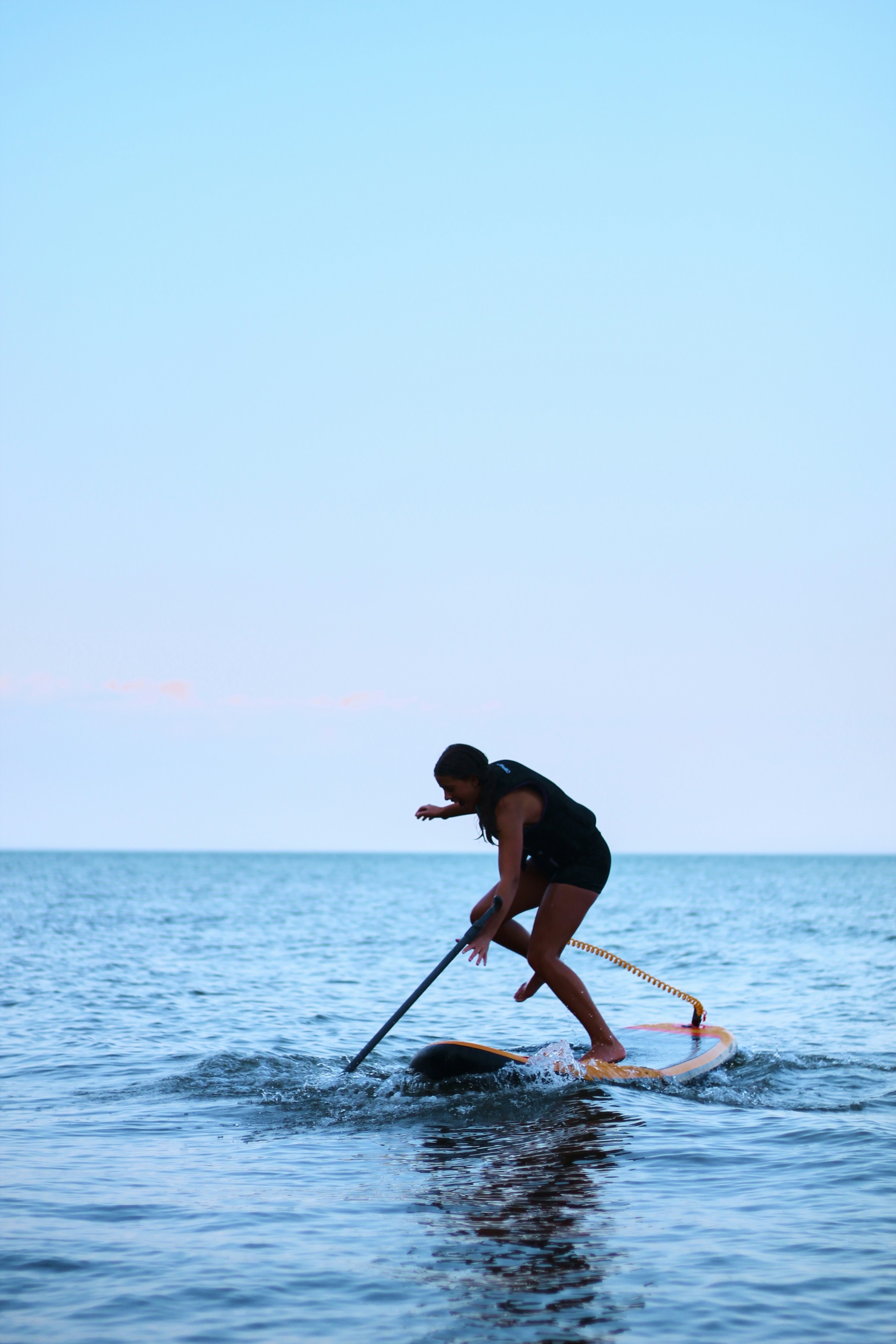 Paddleboarder using a stand-up paddleboard on open lake water during an outdoor recreation session