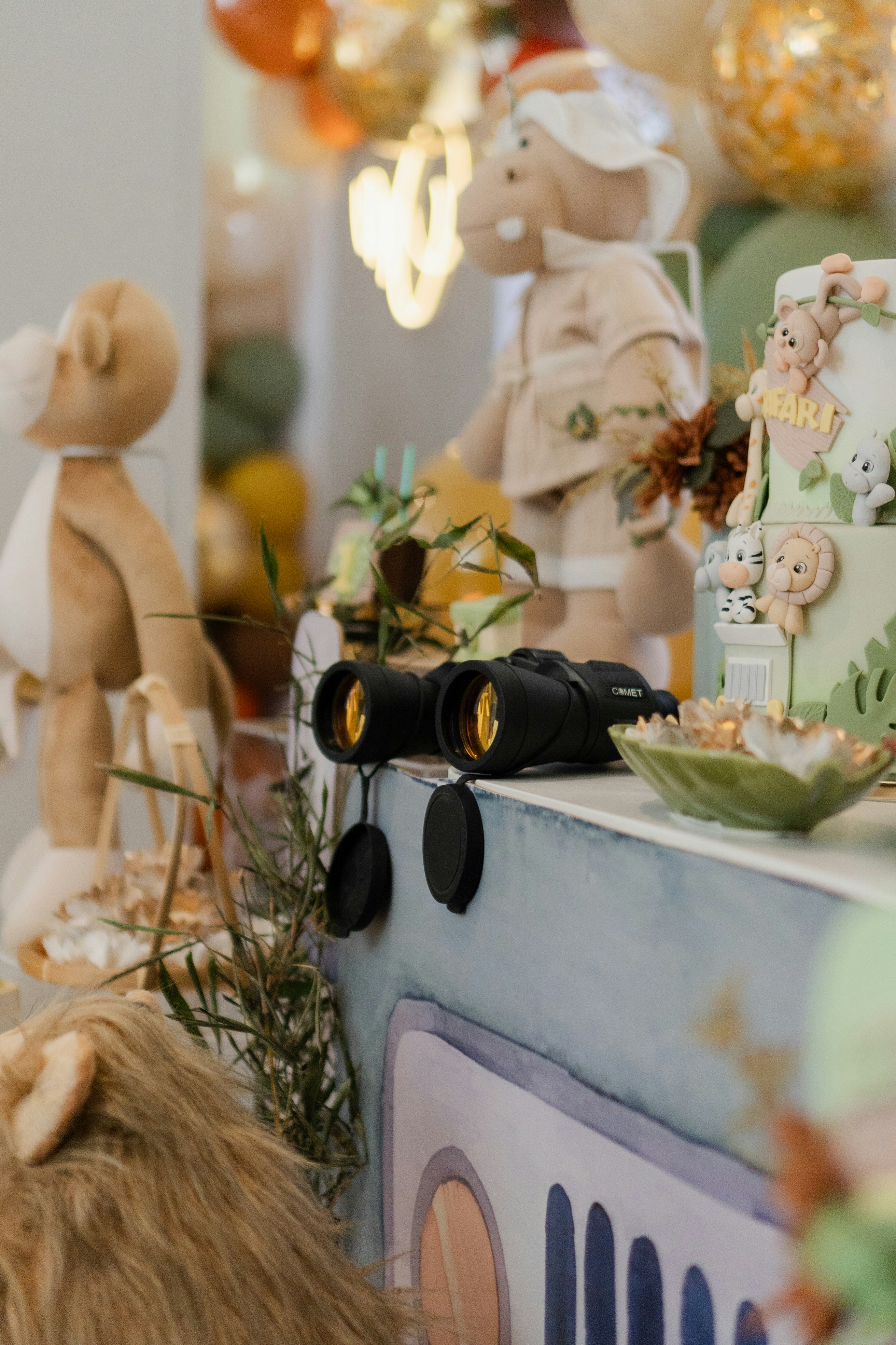 Safari themed party with brown and green jungle decorations and animal figures on table