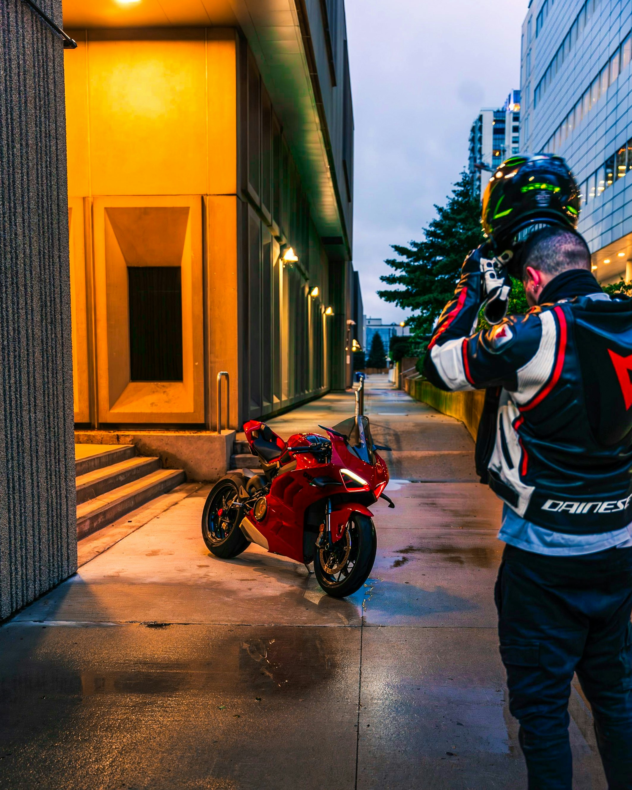 A man standing next to a motorcycle on a sidewalk