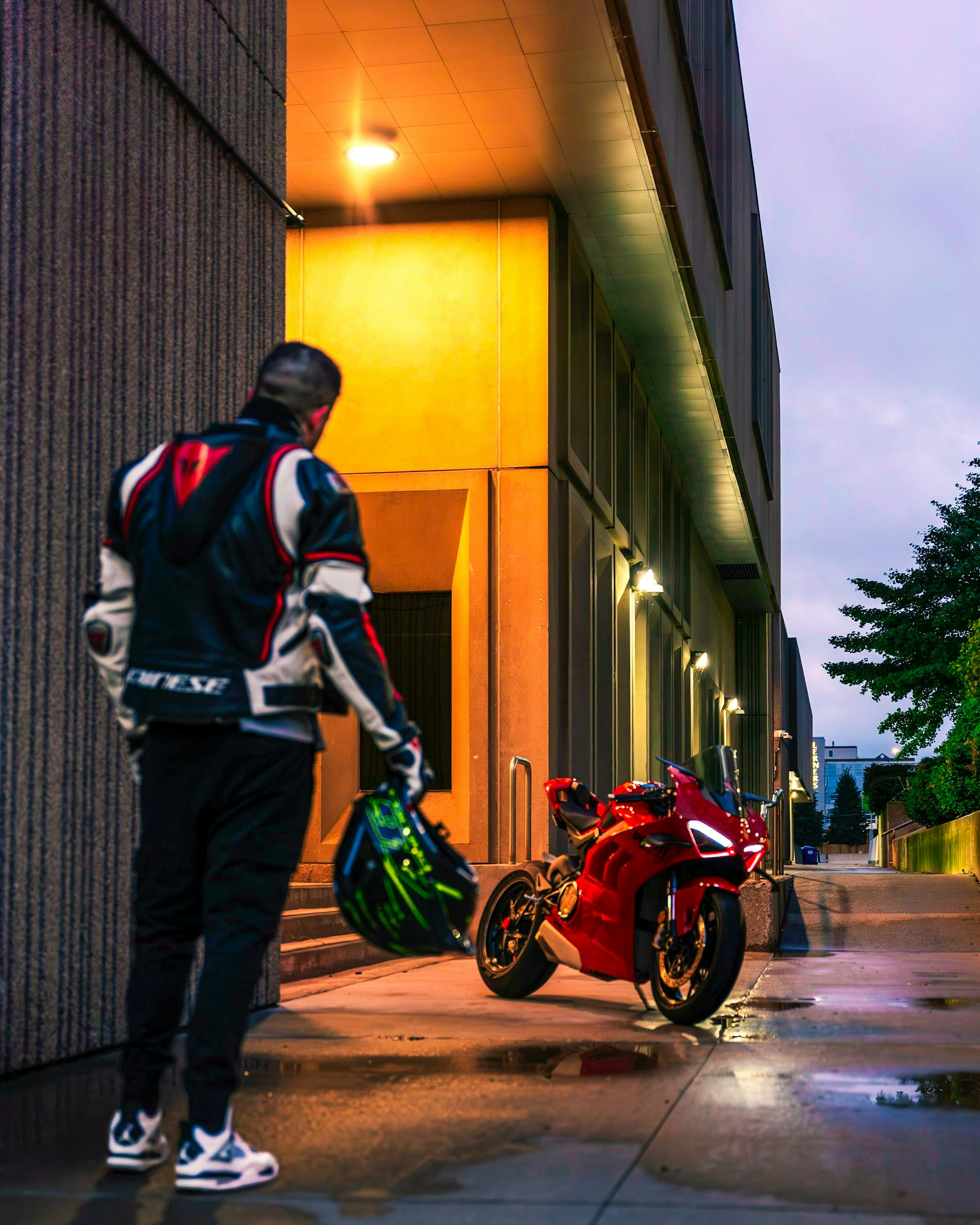 A man standing next to a red motorcycle