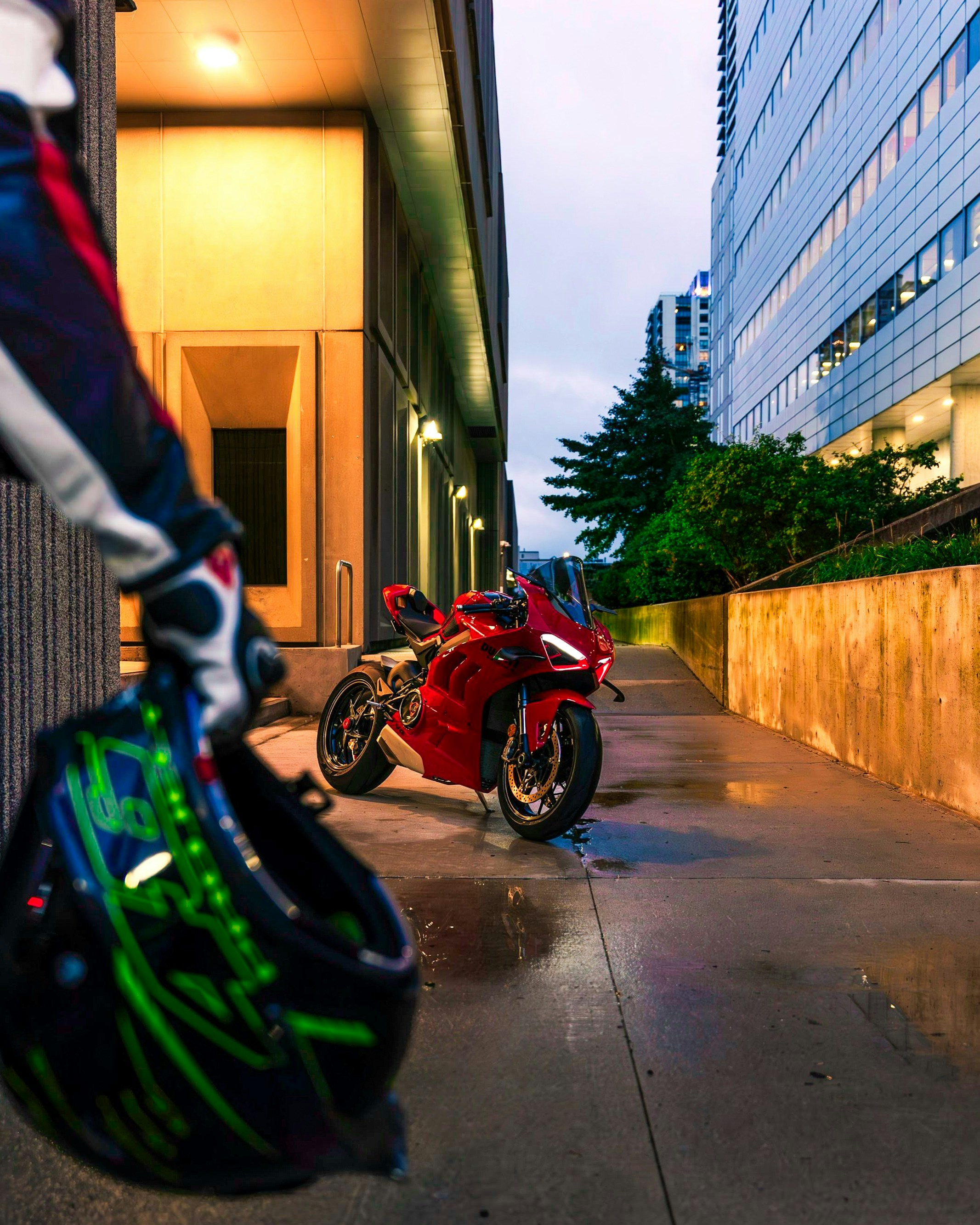 Uma motocicleta vermelha estacionada ao lado de um prédio alto