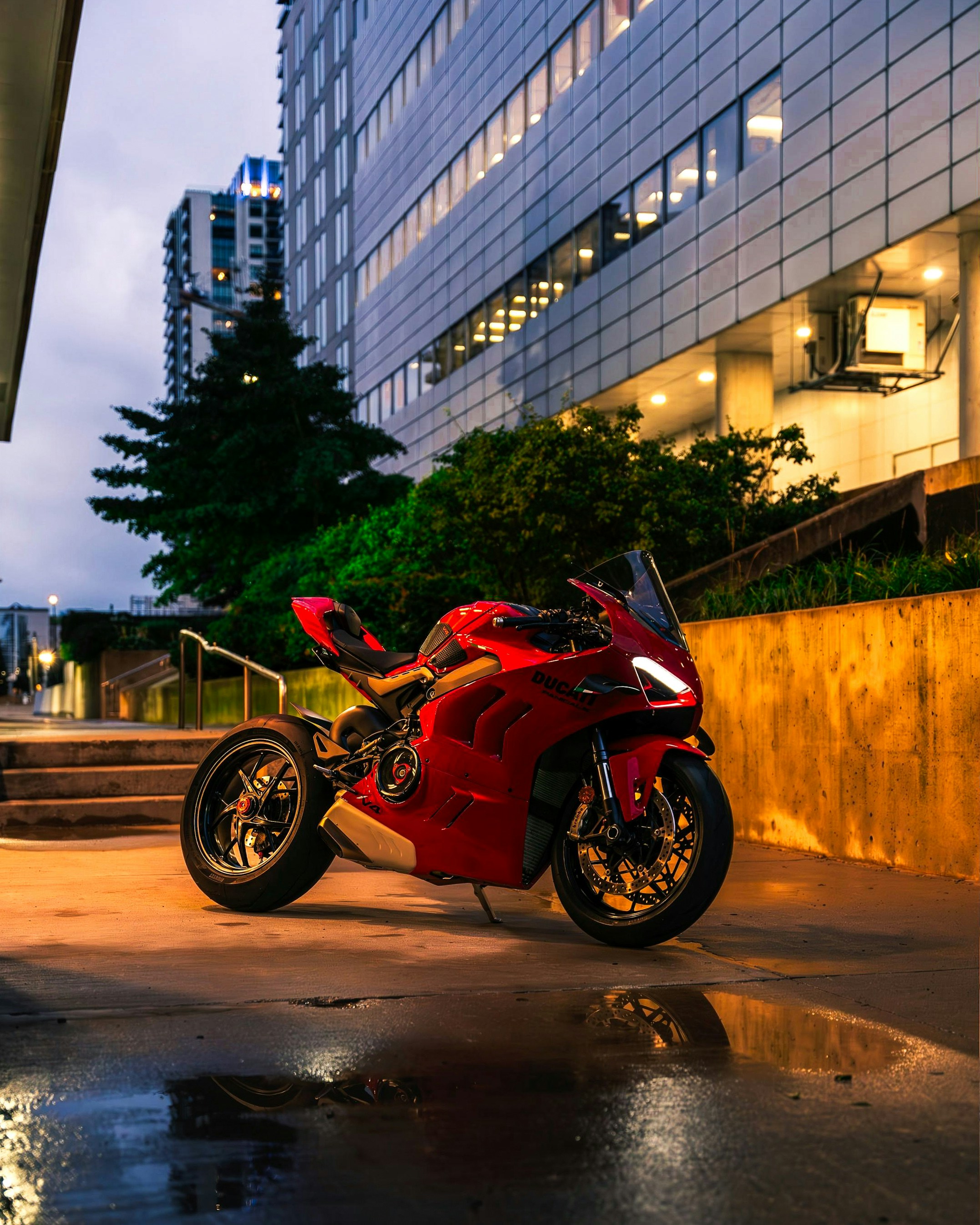 A red motorcycle parked in front of a tall building