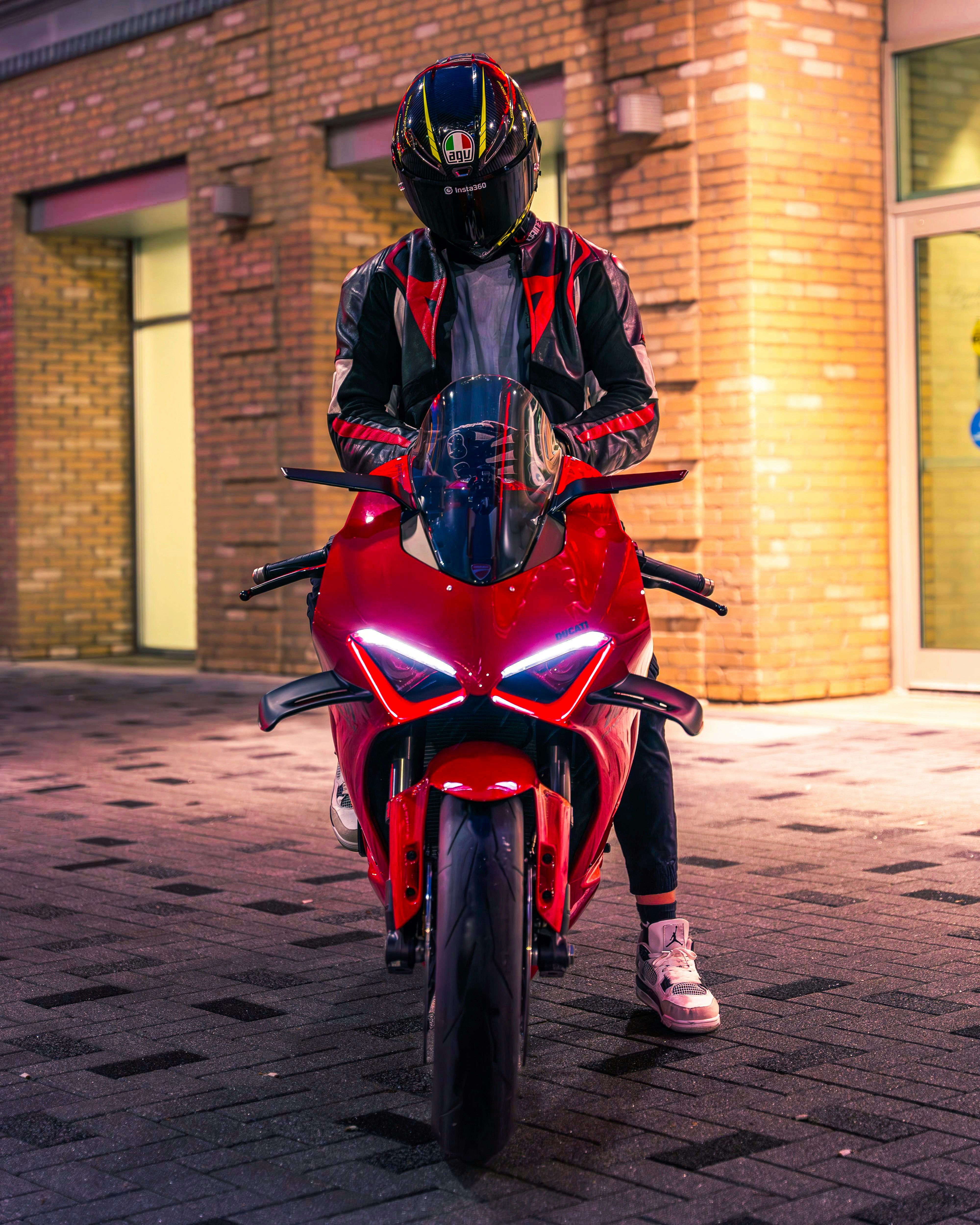 A man is sitting on a red motorcycle