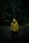 A person in a yellow raincoat standing in the dark