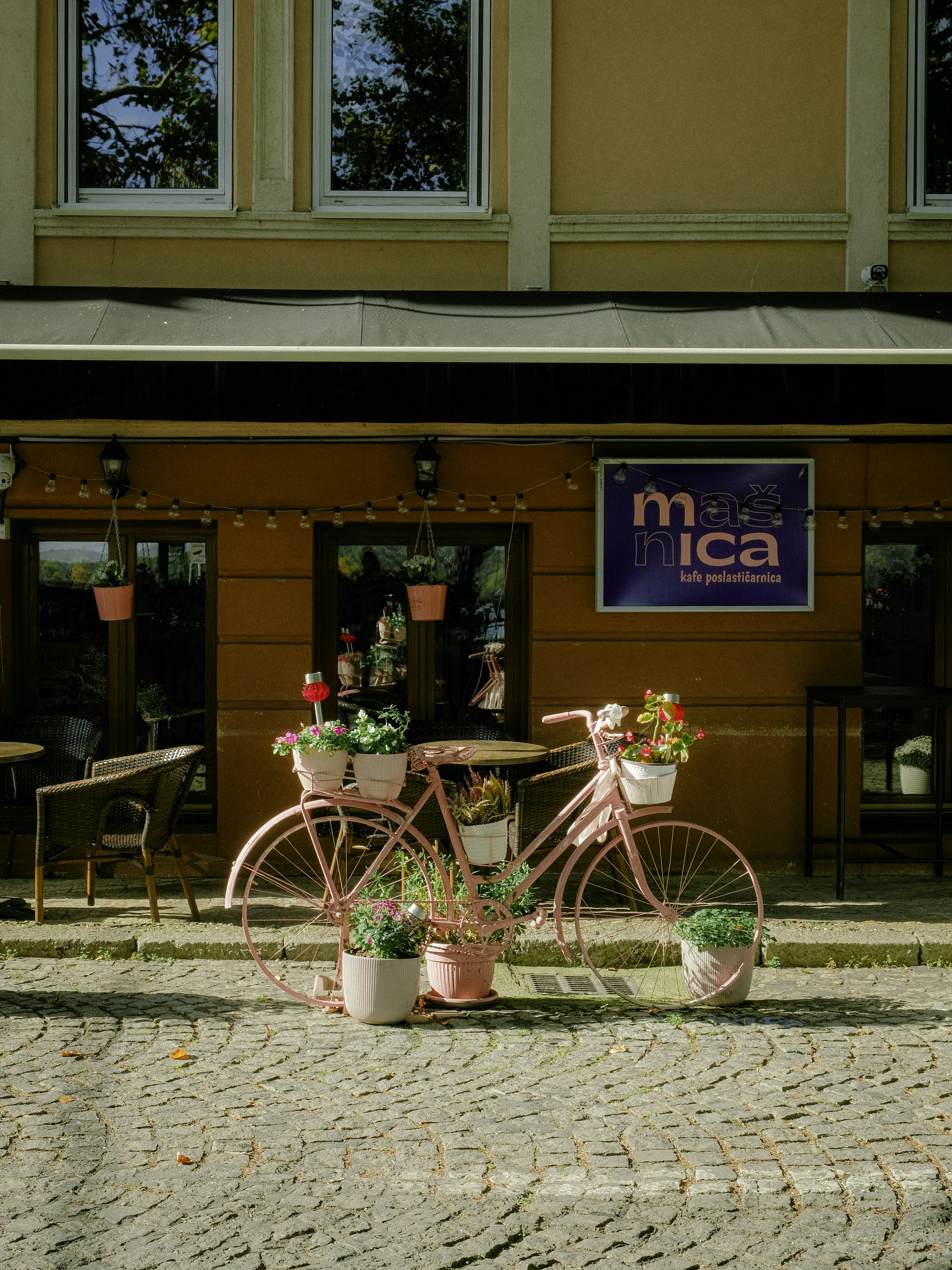 A pink bike parked in front of a building