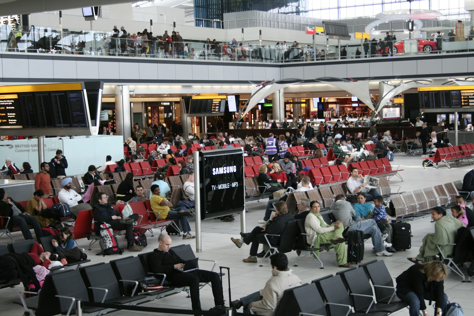 A large group of travellers waiting together in an airport terminal