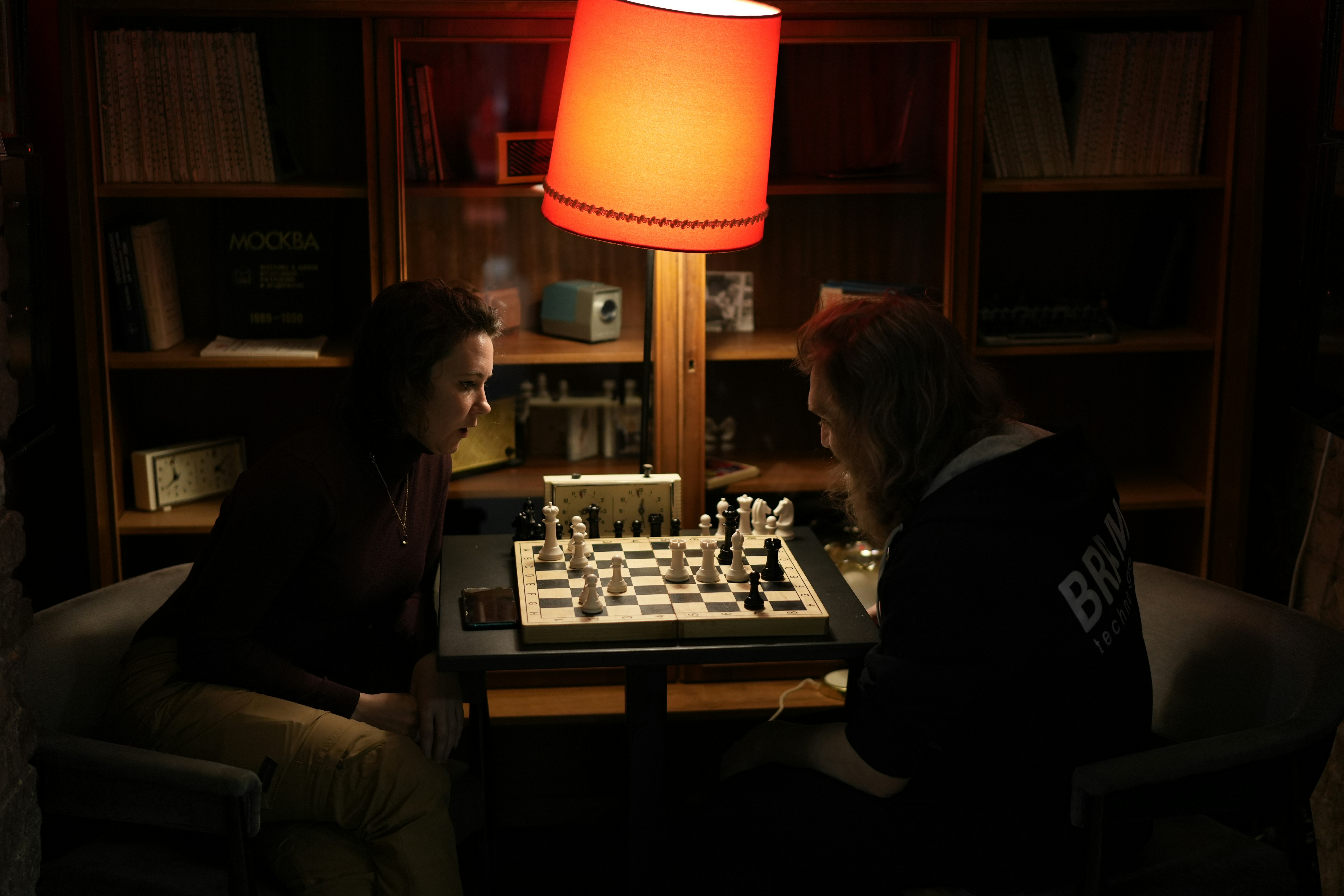 Two people playing chess in a dark room