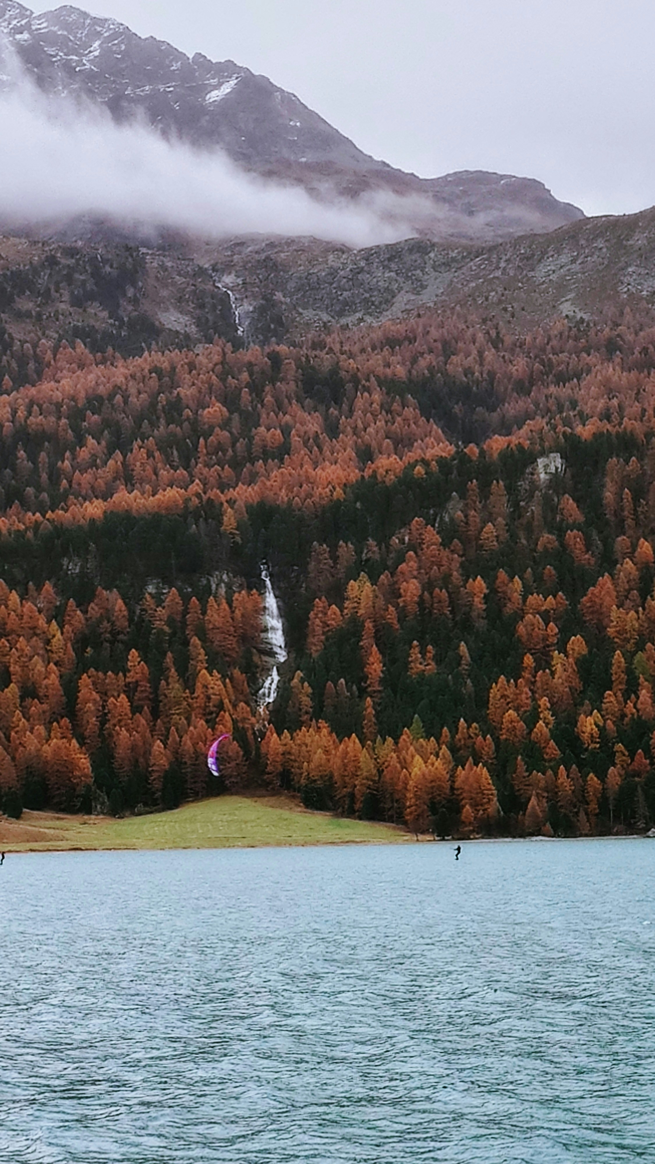 A body of water surrounded by mountains and trees