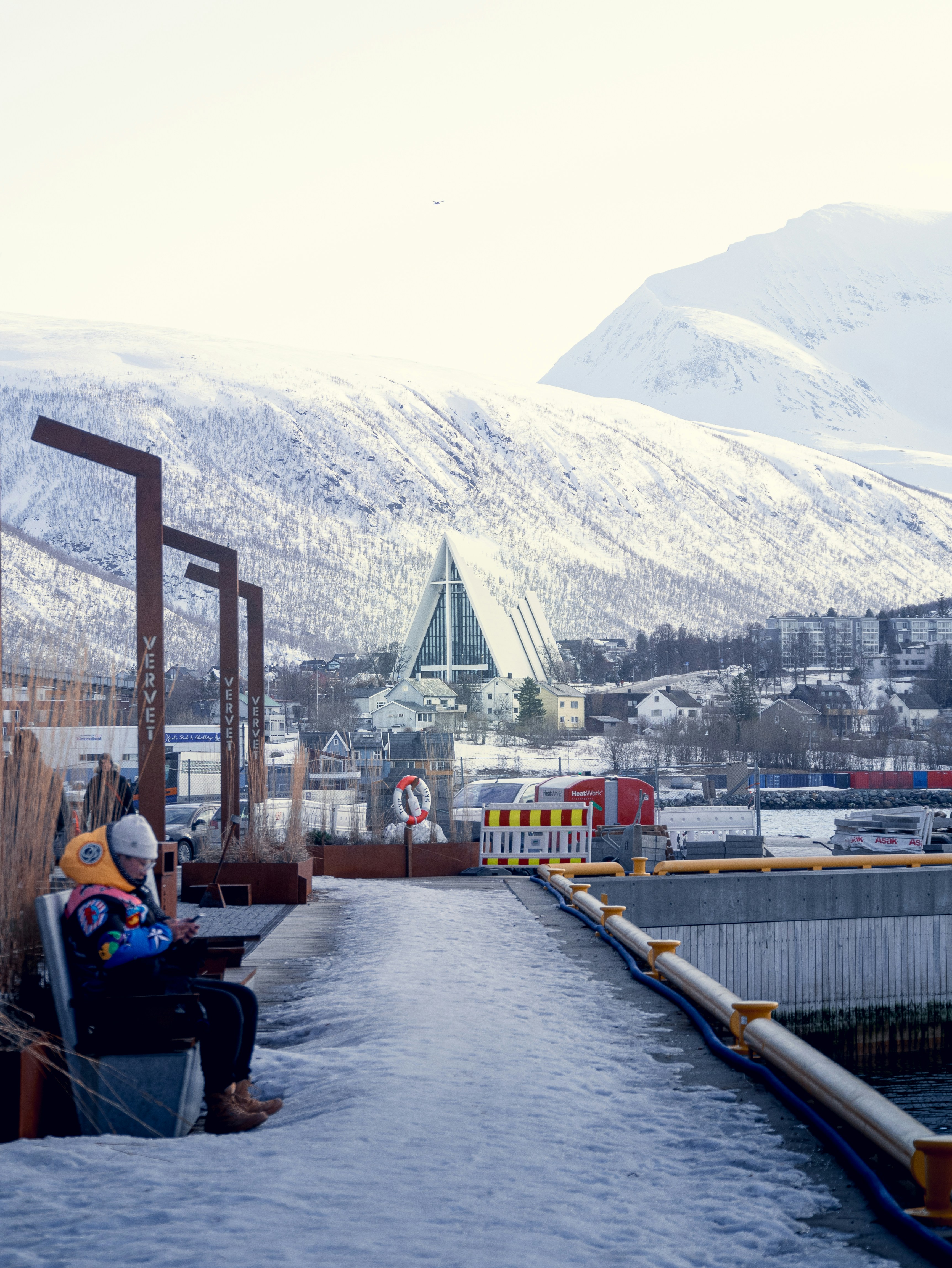 A person sitting on a bench in the snow