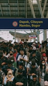 A large group of people standing in front of a train station