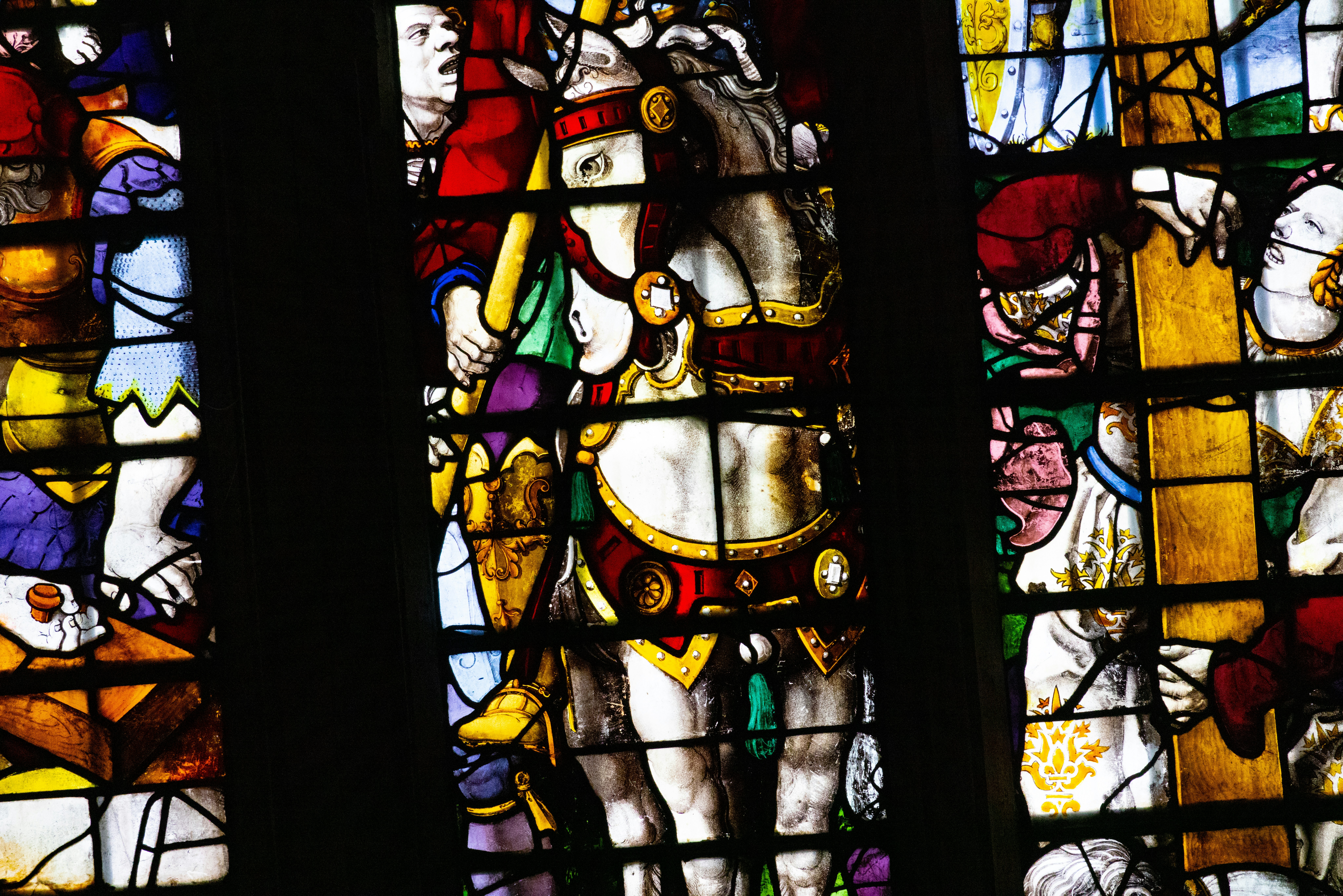 A stained glass window with a man riding a horse