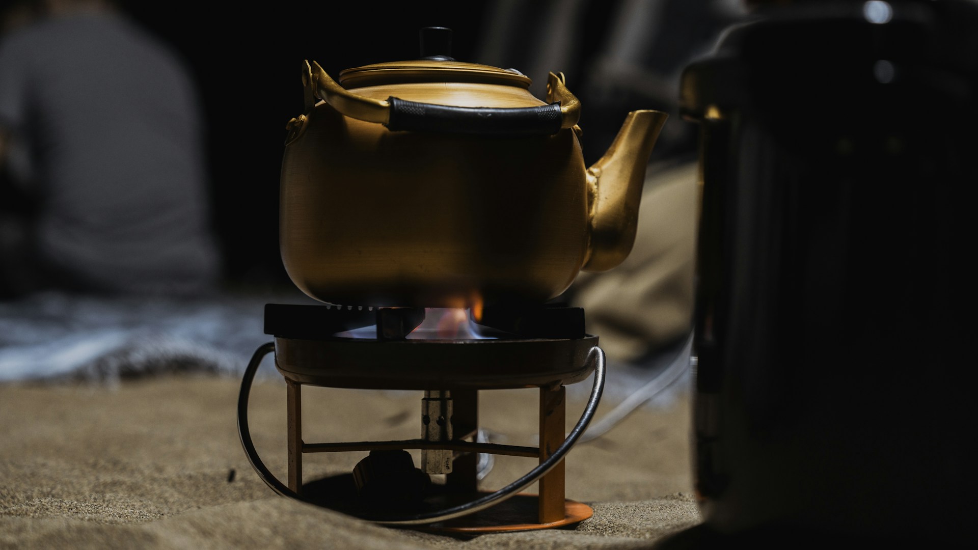 A kettle sitting on top of a stove next to a coffee pot