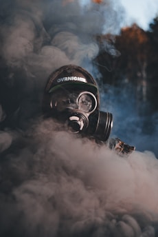 A person wearing a gas mask and smoking a cigarette