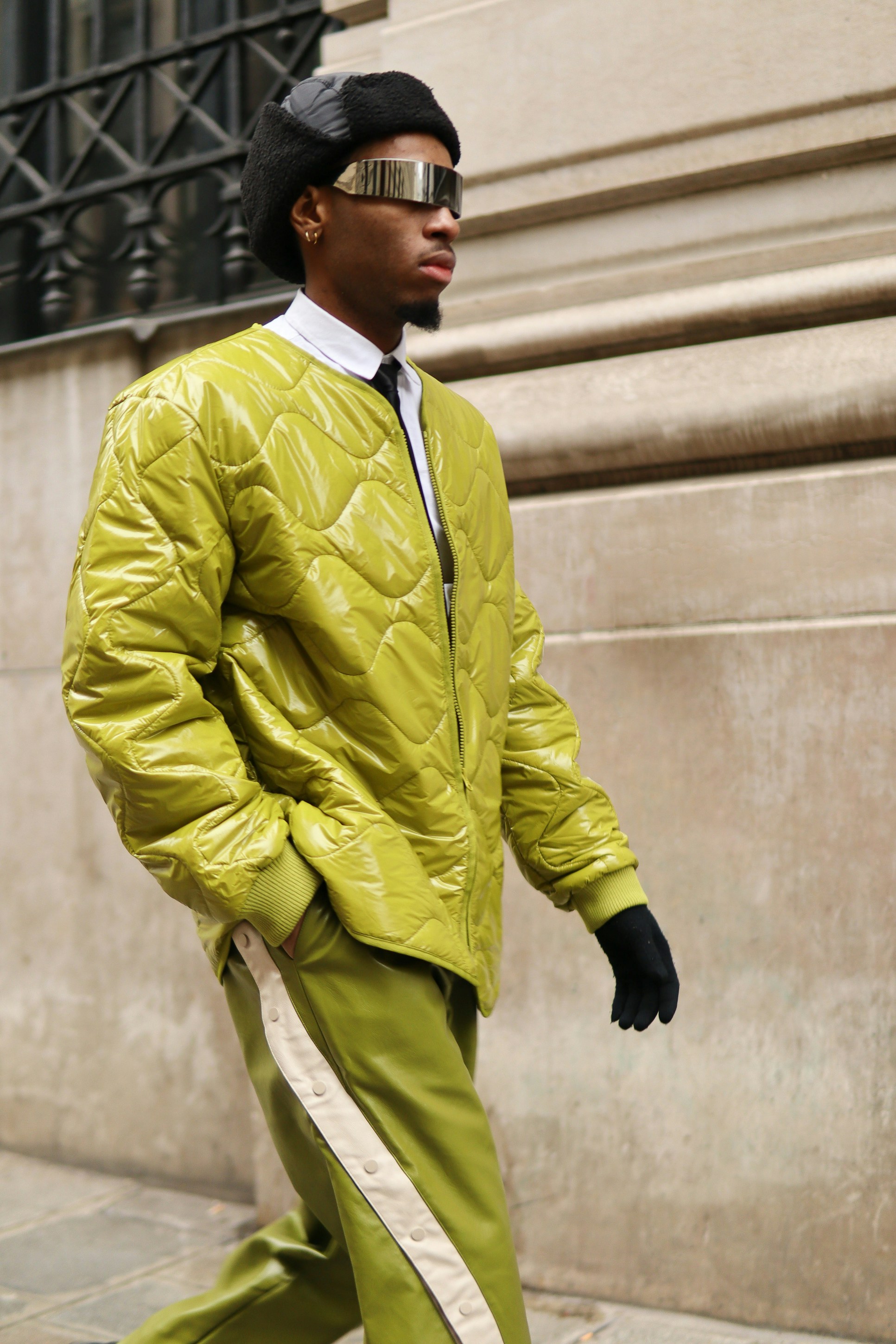 A man walking down a street wearing a yellow jacket