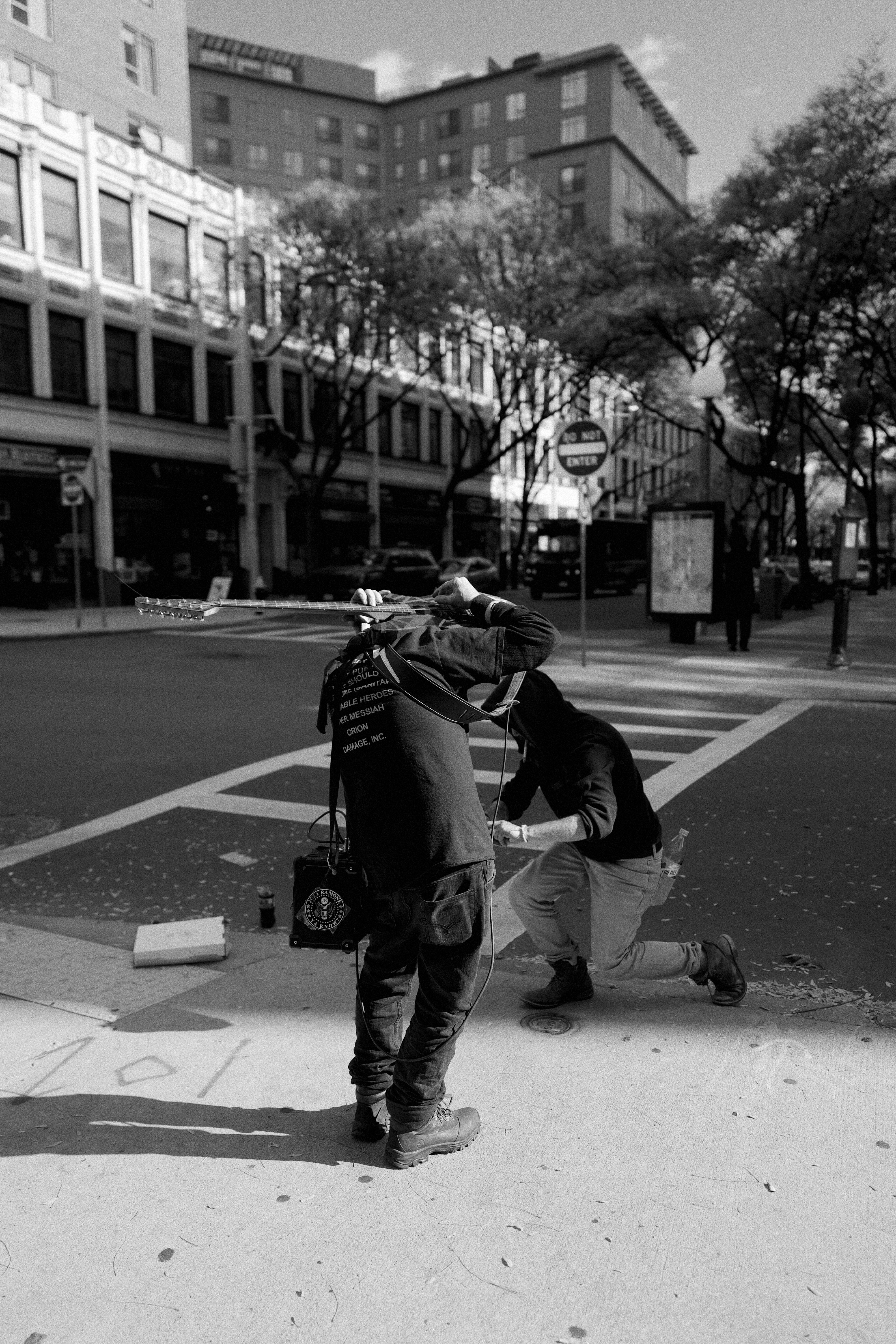 A man standing on the side of a road next to a cross walk