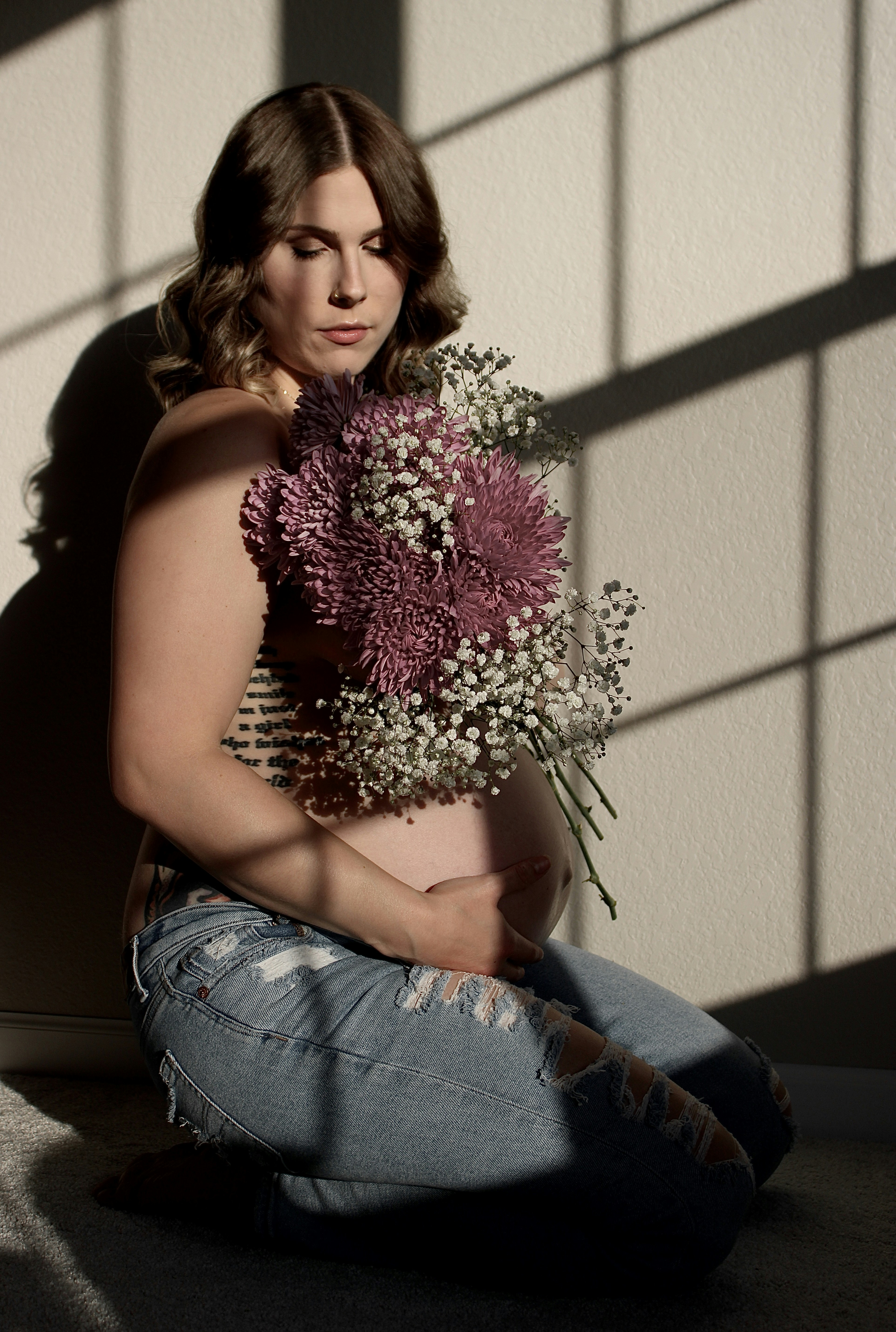 A pregnant woman holding a bouquet of flowers