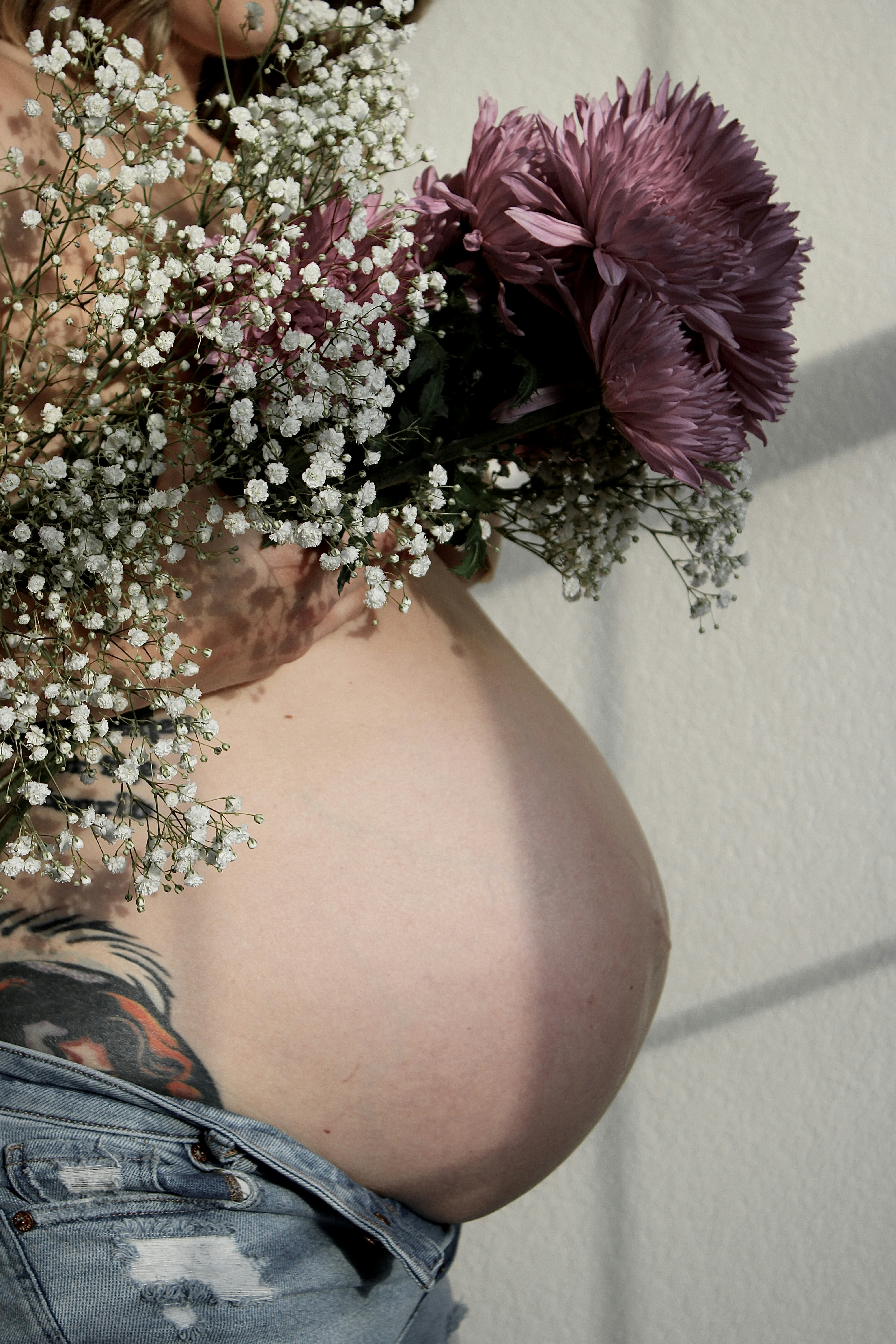 A pregnant woman holding a bouquet of flowers