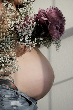 A pregnant woman holding a bouquet of flowers