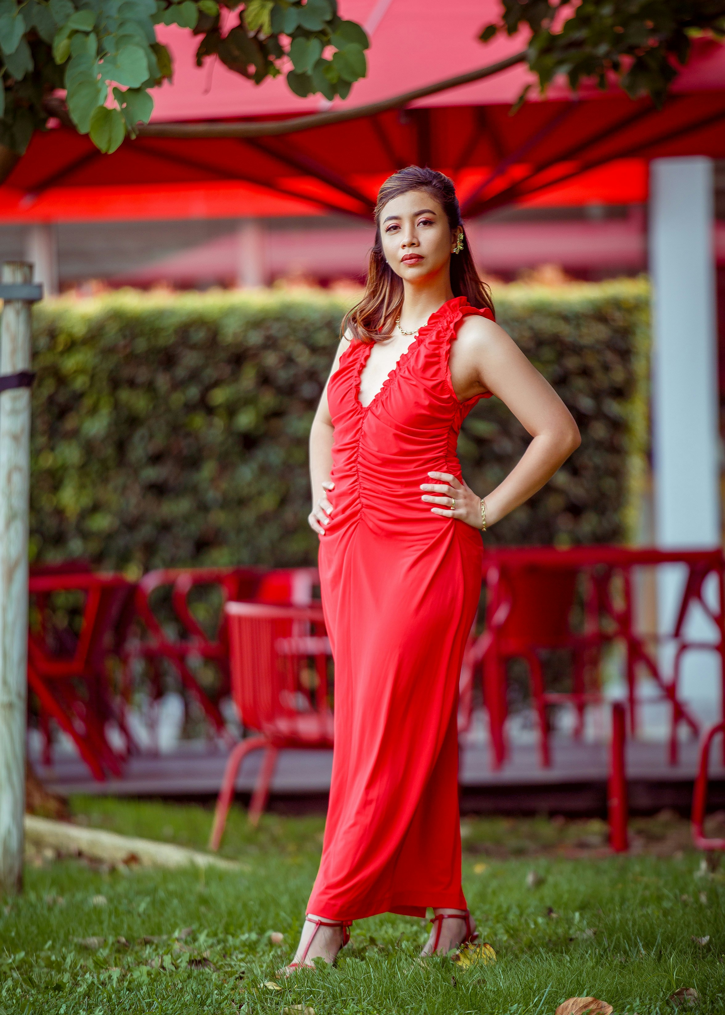 A woman in a red dress standing in the grass