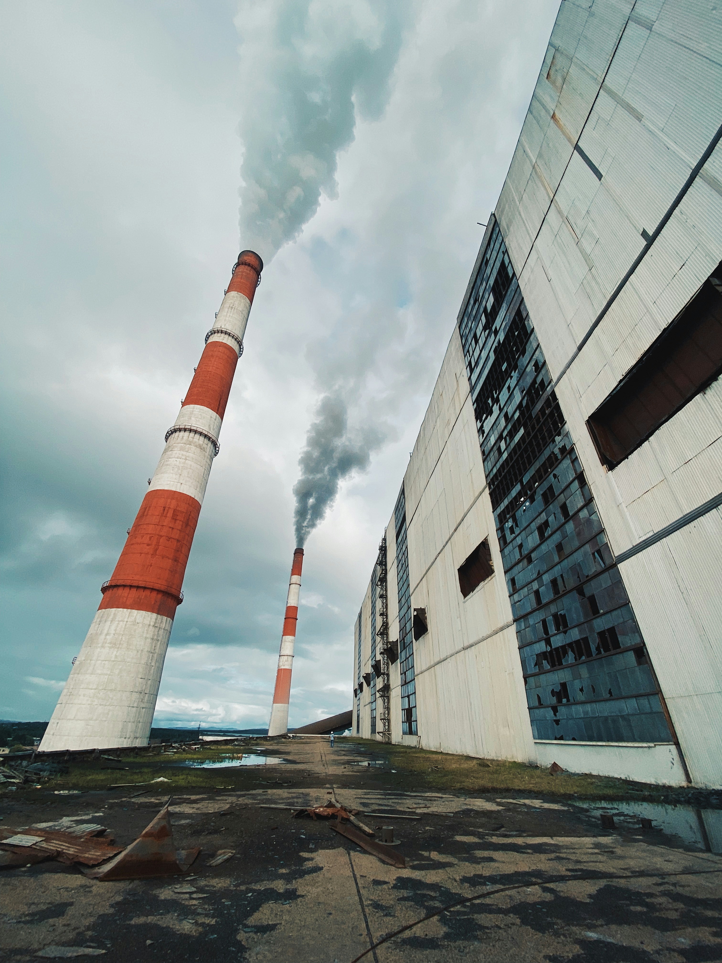 Une usine avec de la fumée qui s’échappe de ses cheminées