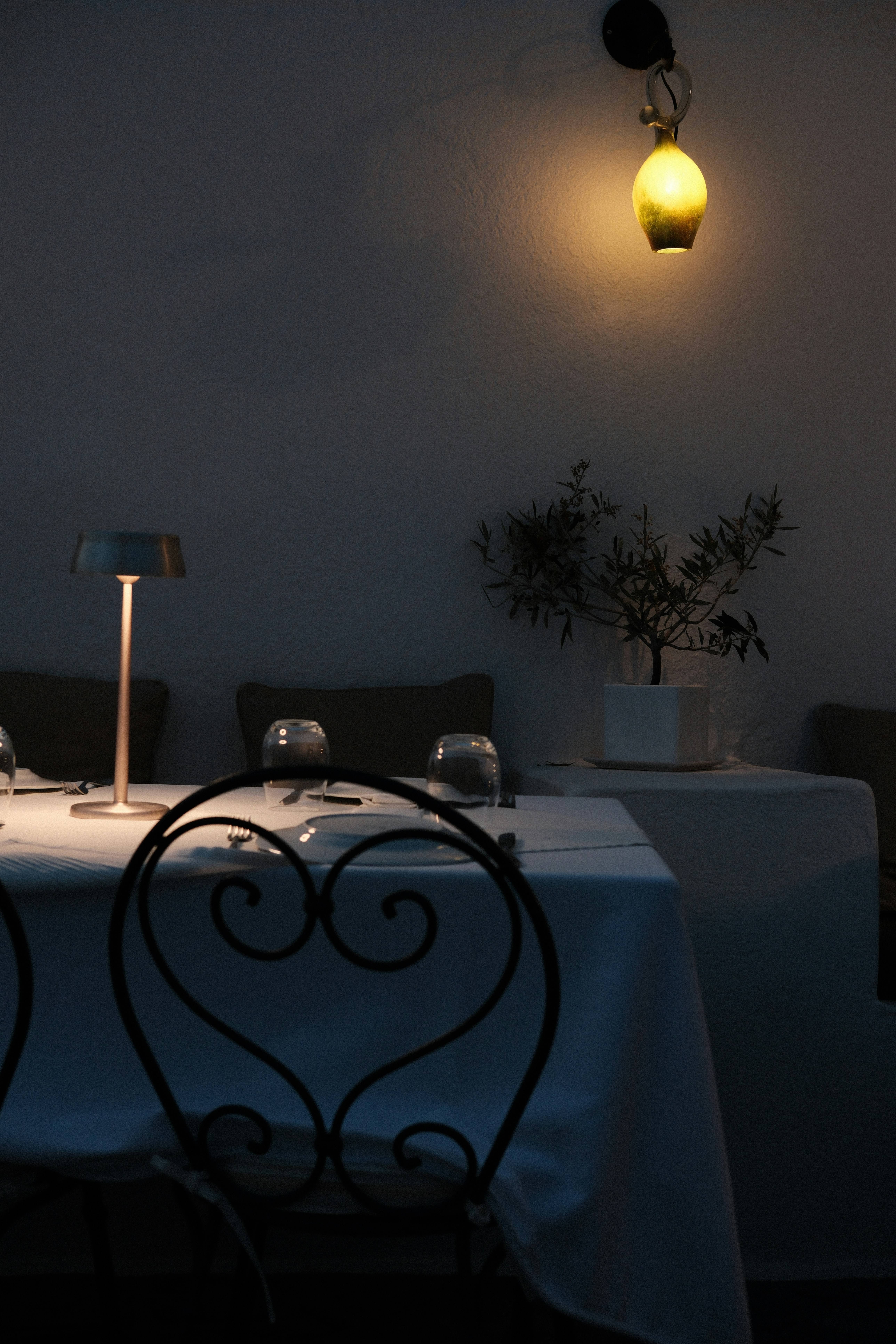 A table with a white table cloth and a lamp