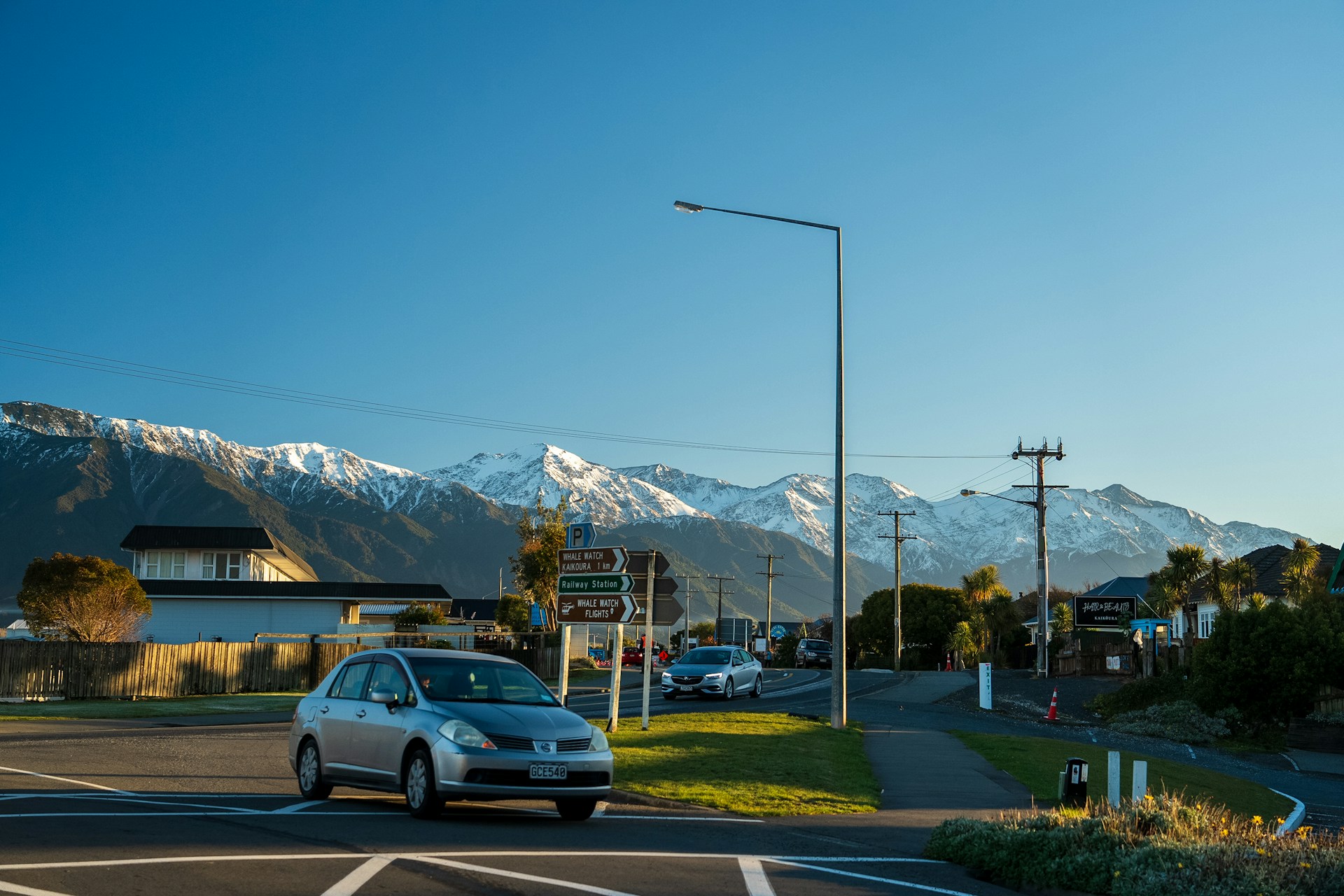 A car driving down a street with a mountain in the background