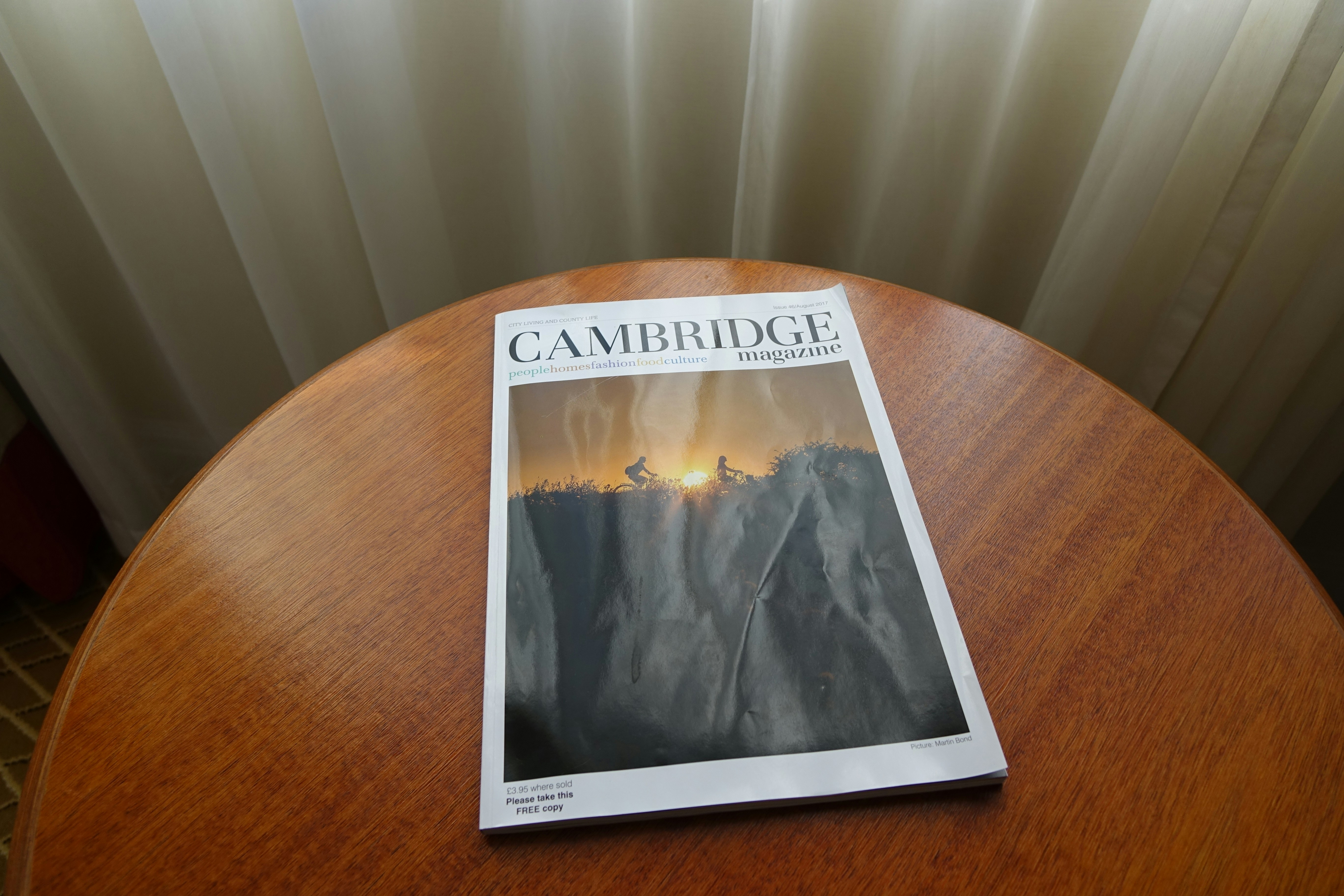 A magazine sitting on top of a wooden table