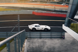 A white sports car driving down a race track