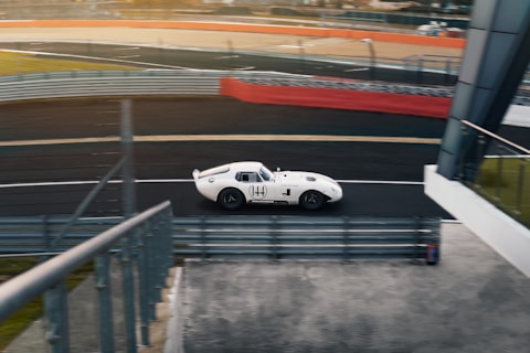 A white sports car driving down a race track