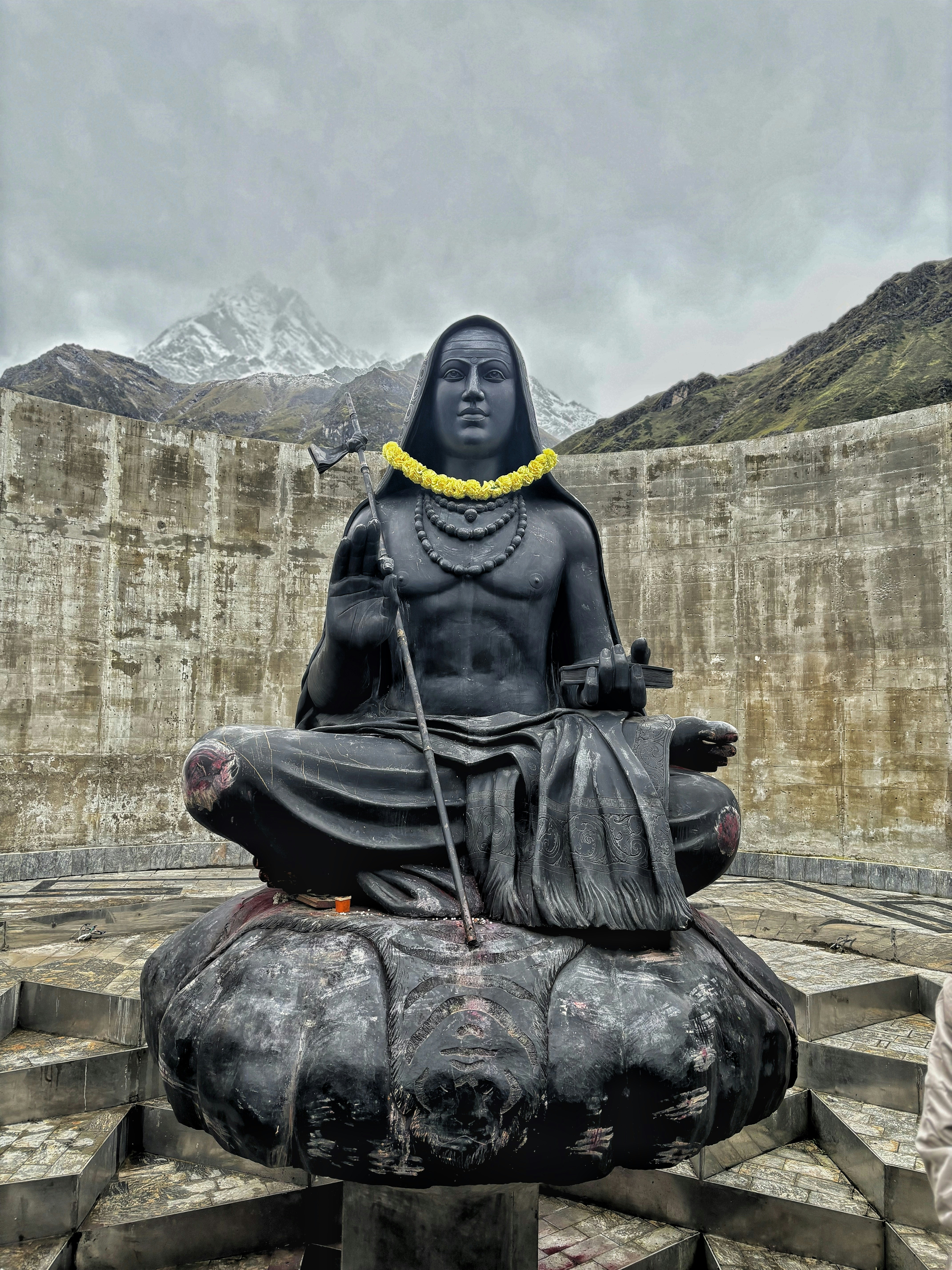 A statue of buddha sitting on top of a stone structure