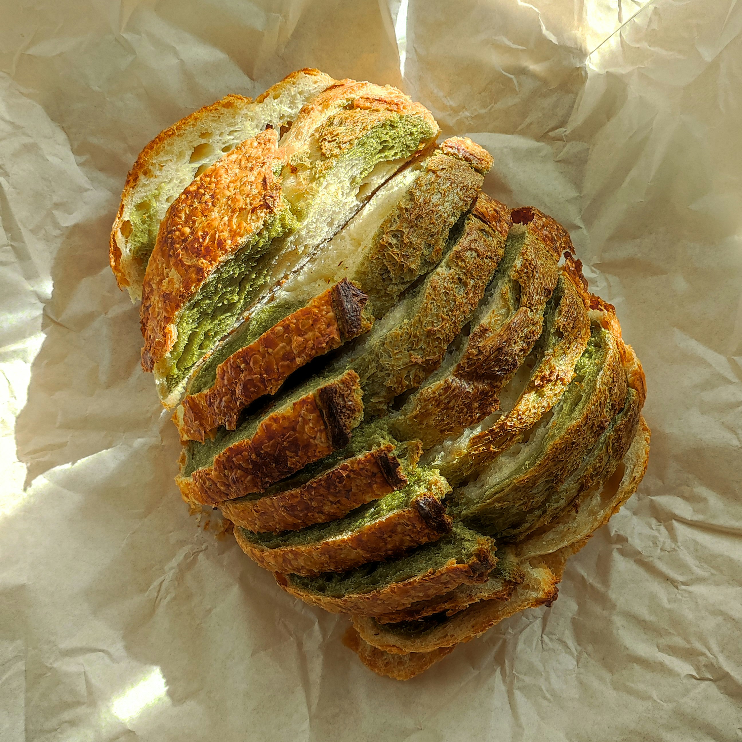 A sliced loaf of bread sitting on top of a piece of wax paper