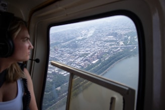 A woman sitting in an airplane looking out the window