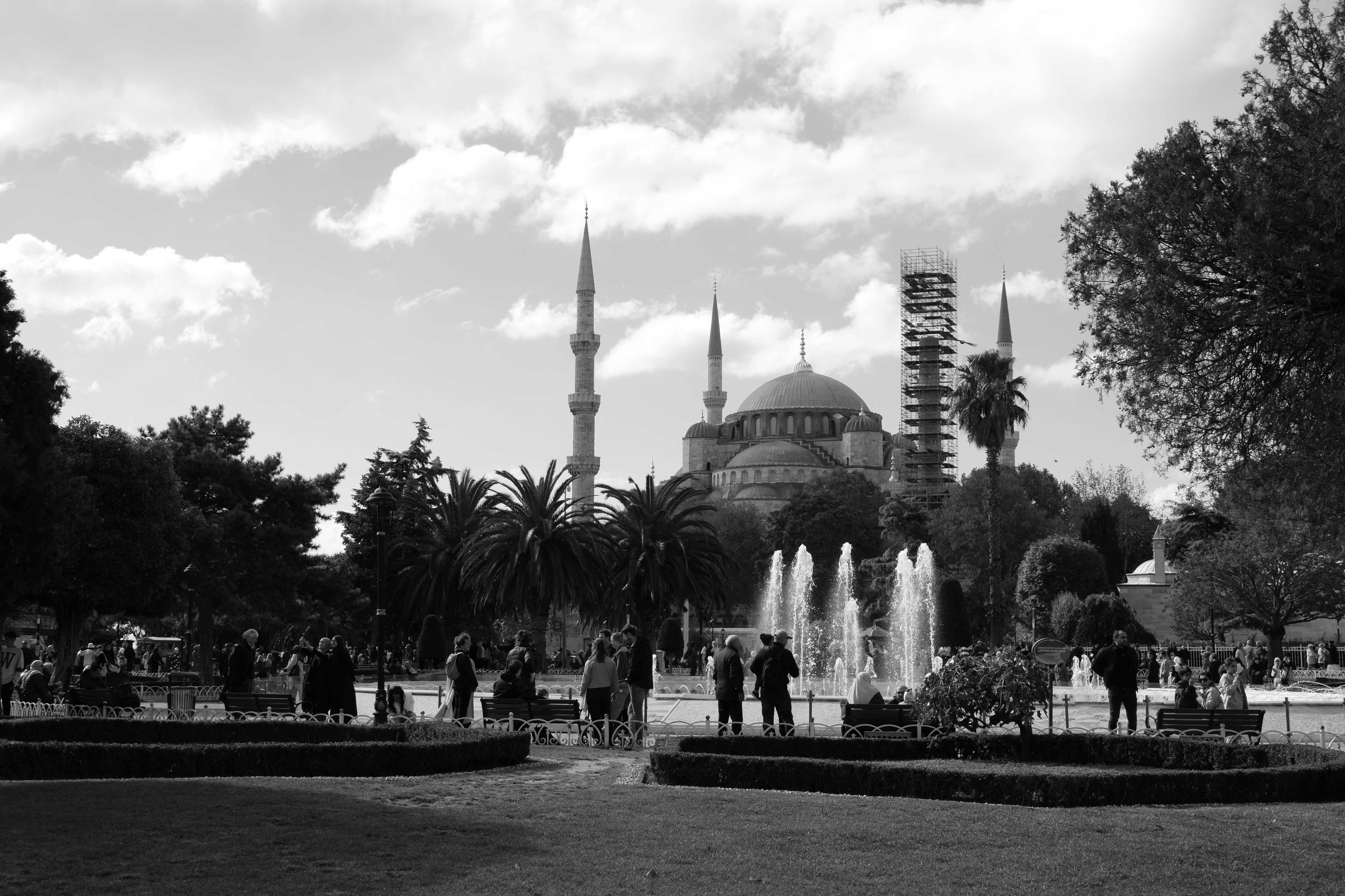 A black and white photo of a fountain in a park