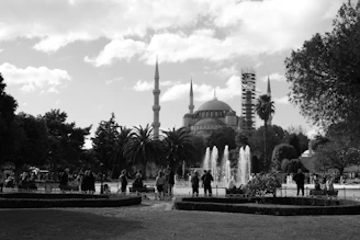 A black and white photo of a fountain in a park