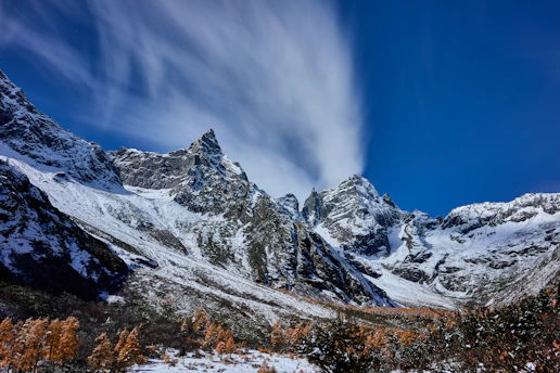 A snow covered mountain range under a blue sky