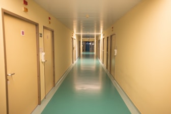 A long hallway with a blue floor and yellow walls