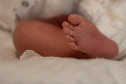 A close up of a baby's foot on a blanket