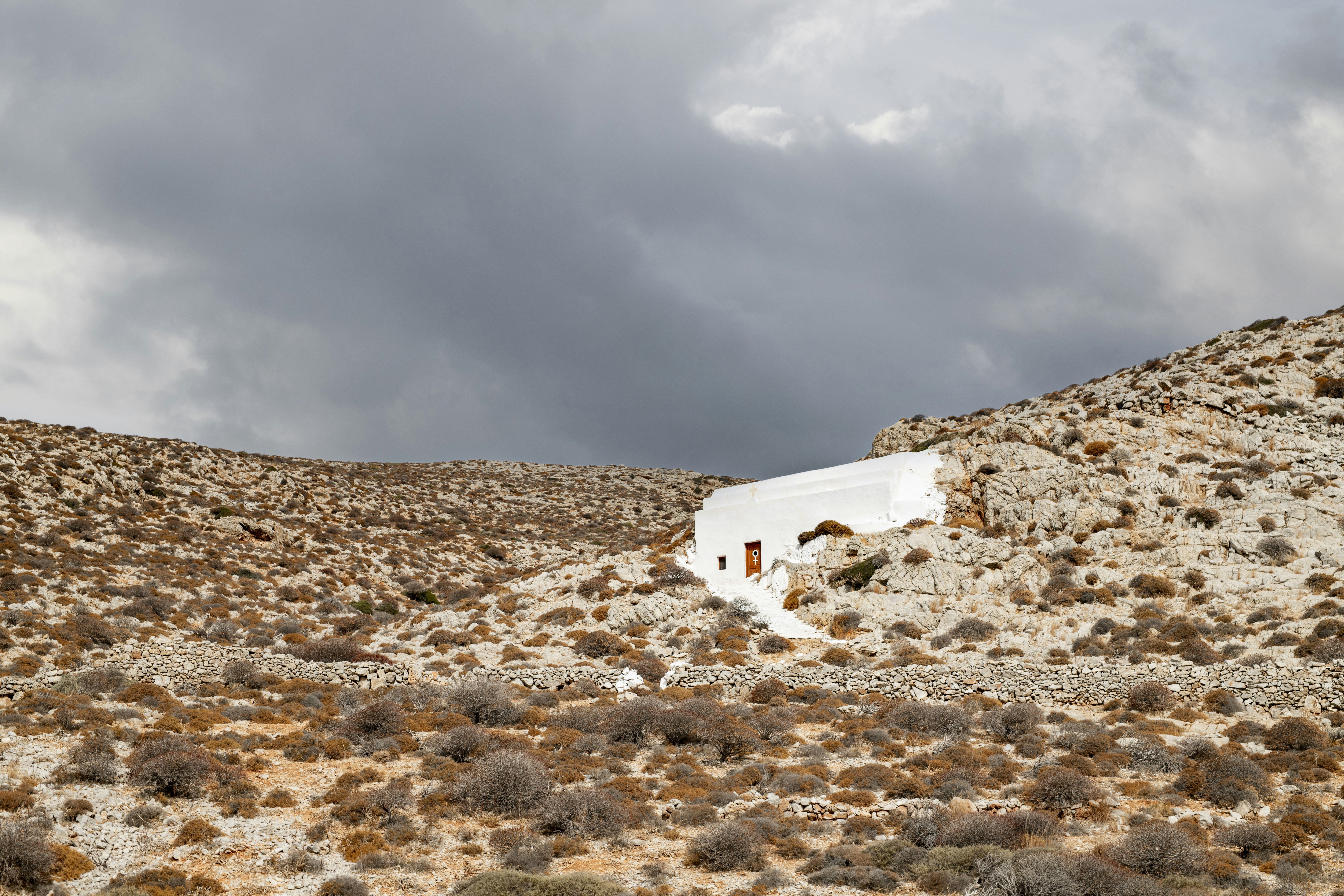A white building sitting on the side of a hill