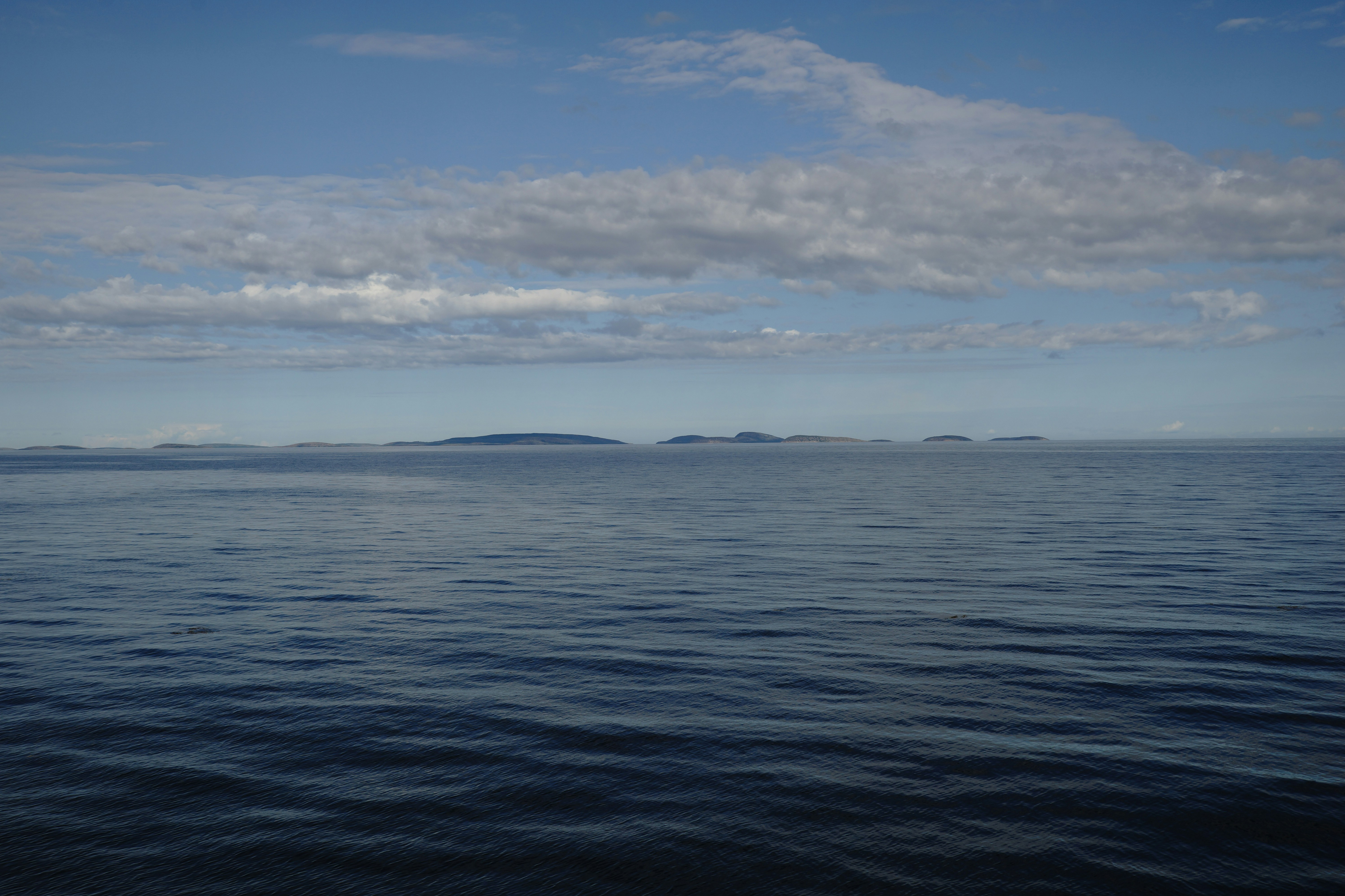Une grande étendue d’eau sous un ciel bleu nuageux