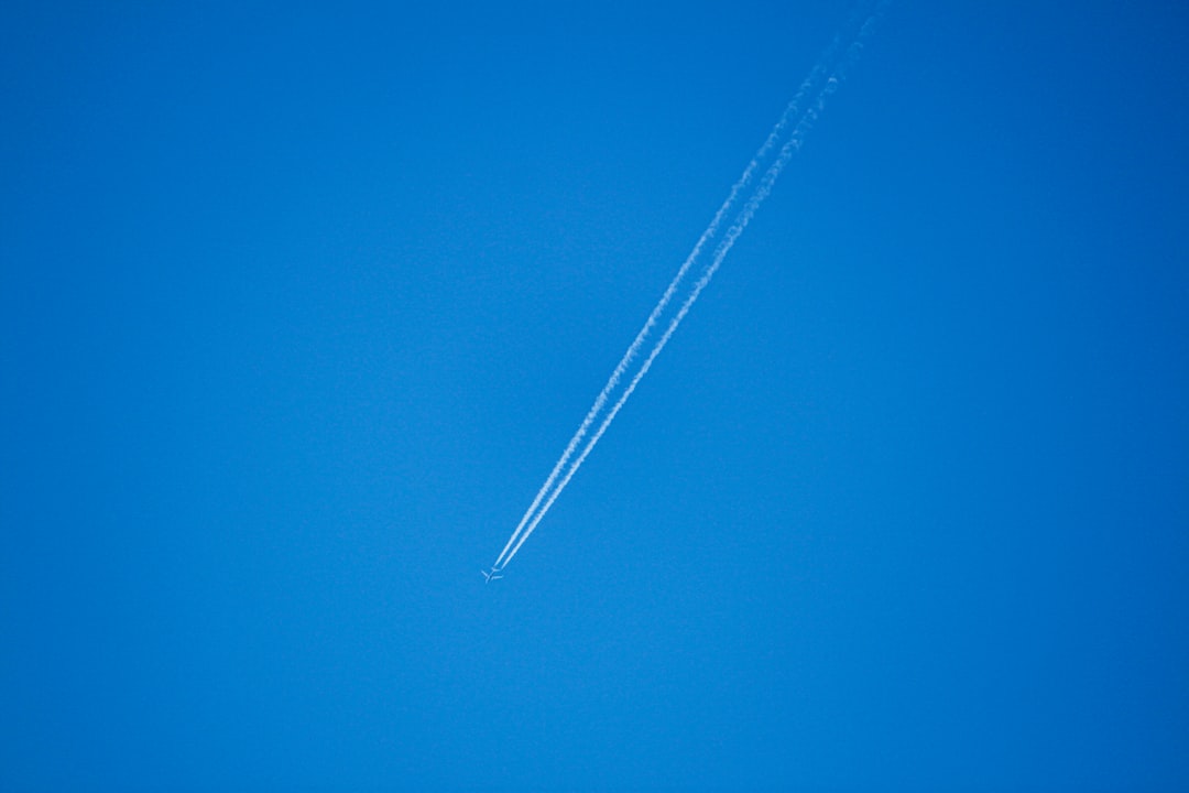 An airplane is flying in the blue sky,
