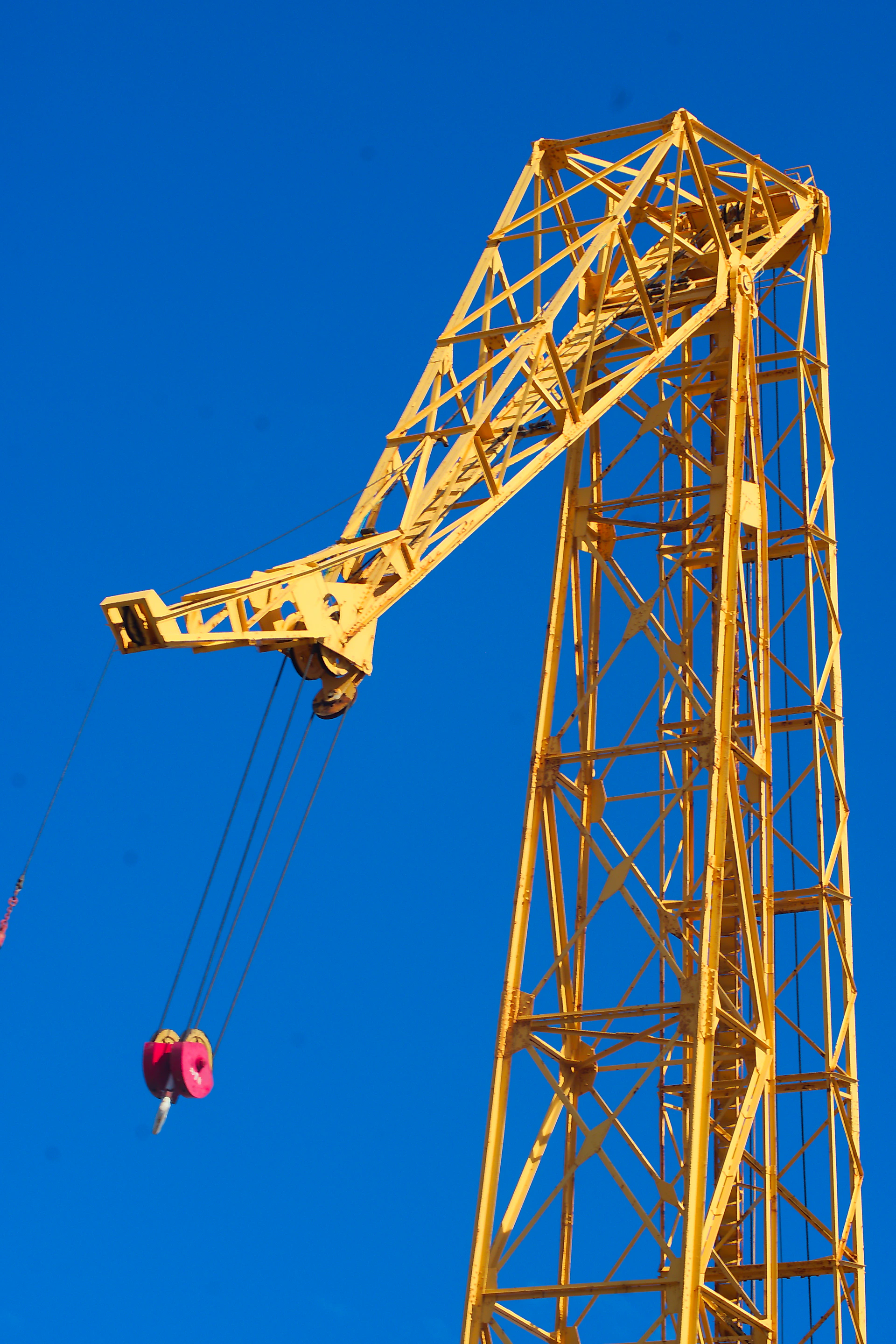 A crane is lifting a red object into the air