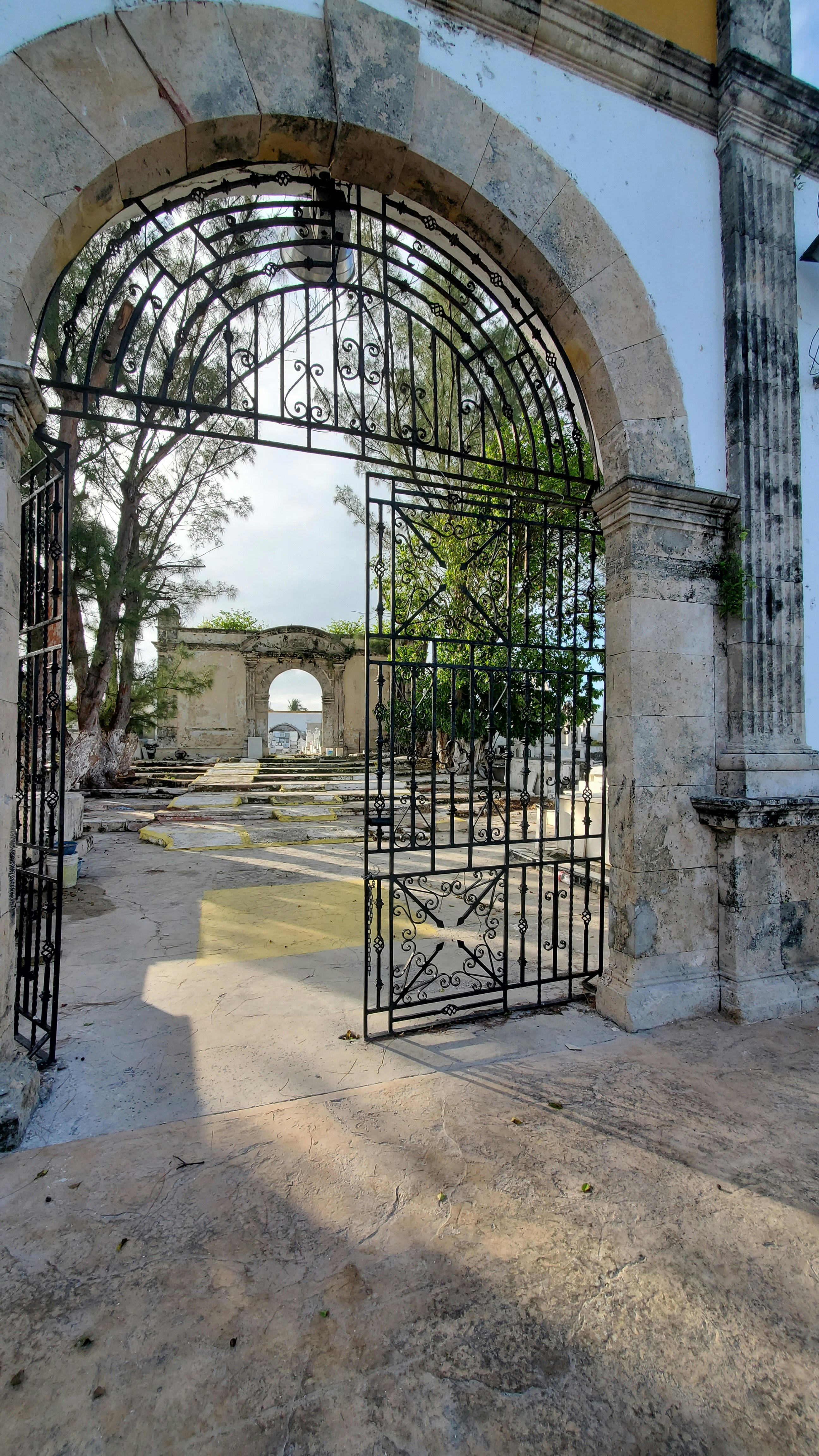 A gated entrance to a building with a clock tower in the background