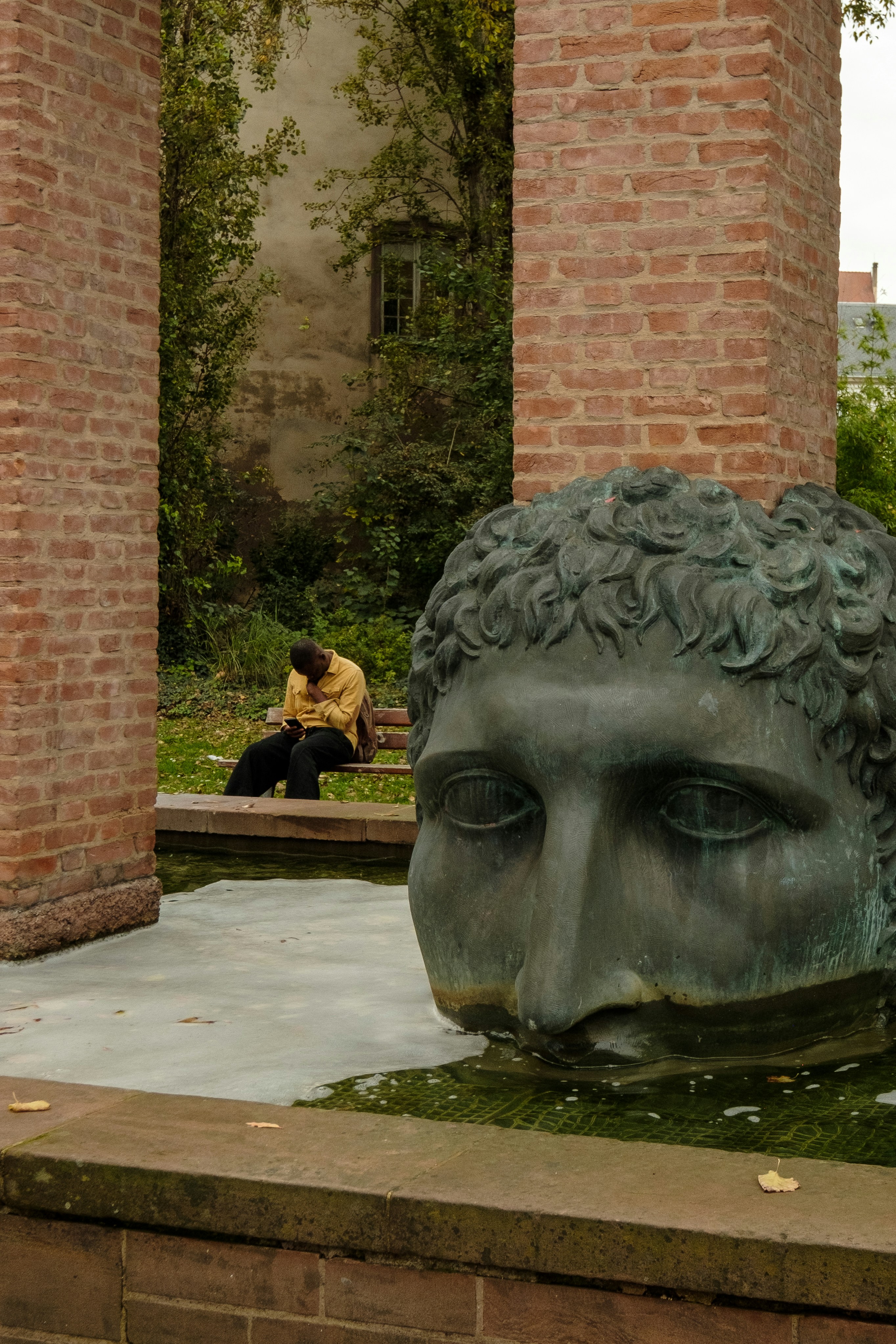 A man sitting on a bench next to a statue