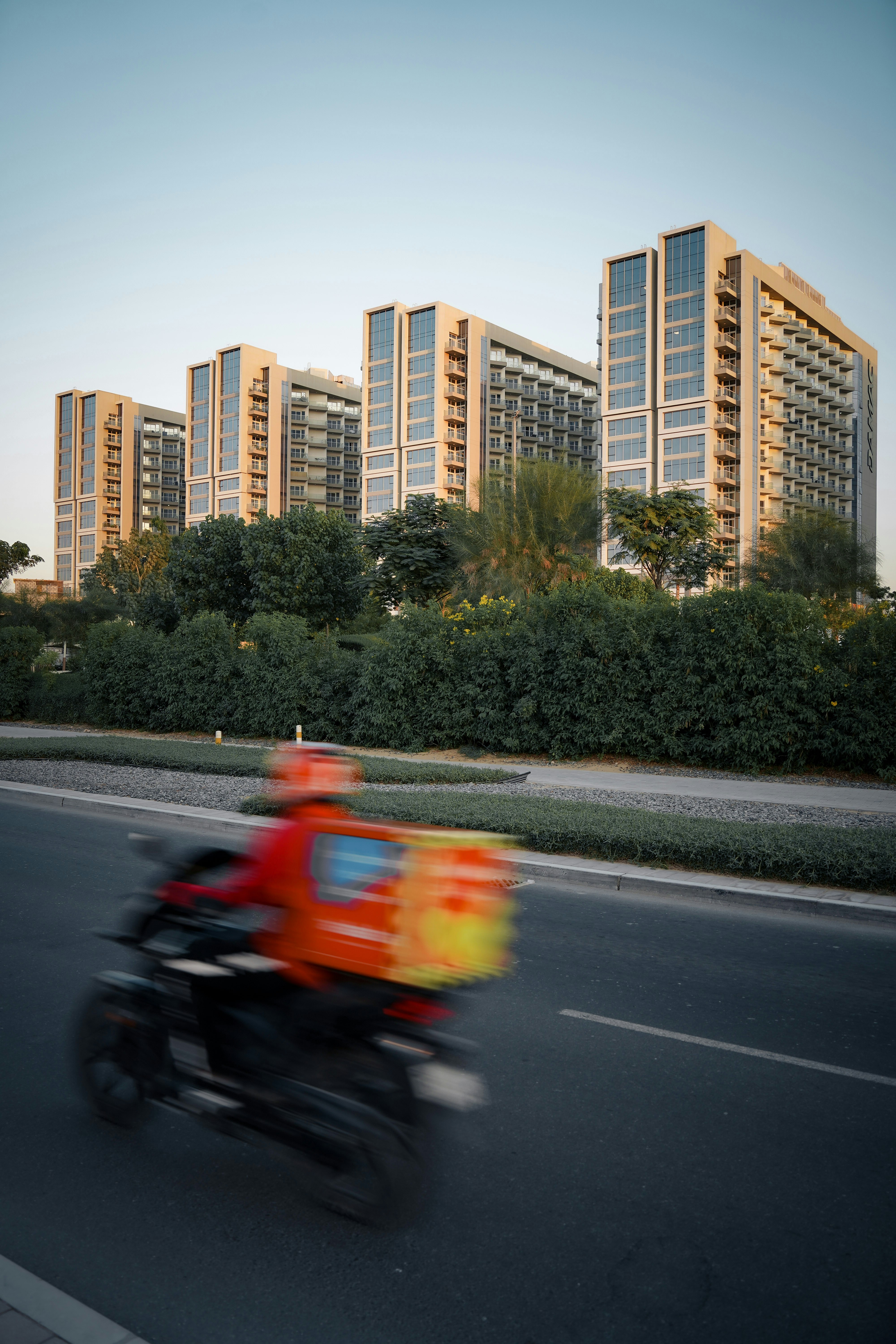 A man riding a motorcycle down a street next to tall buildings