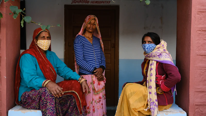 Women wearing face masks seated at a doorway